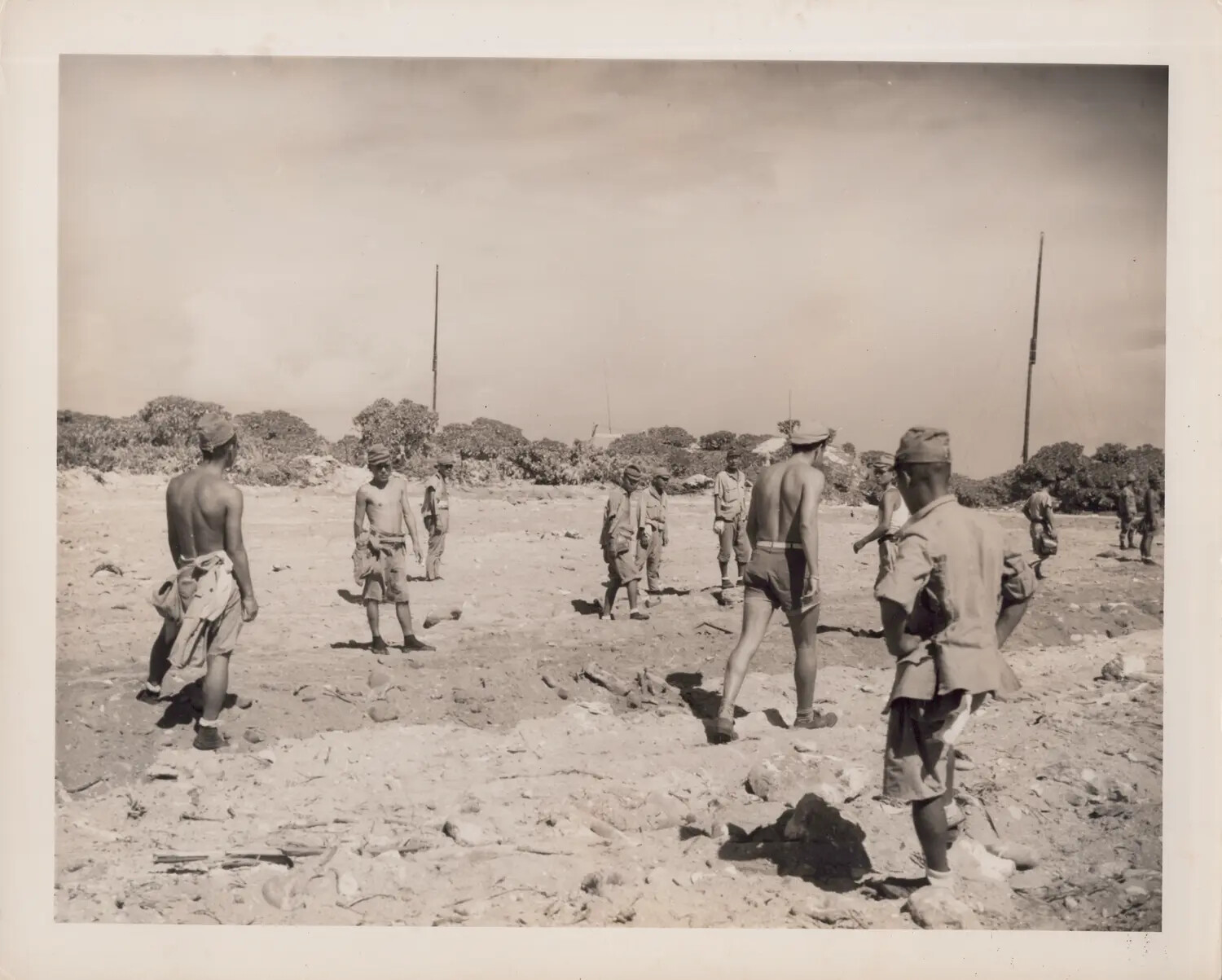 Men Gathered on Open Ground Near Communications Antennas, Pacific Island, World War II