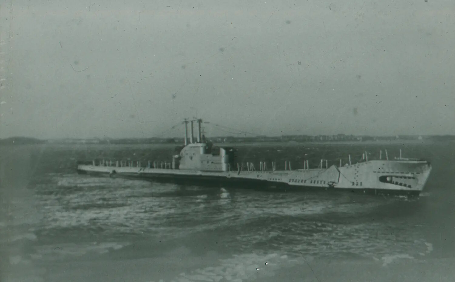WWII-Era Submarine Underway on the Surface Near Coastline
