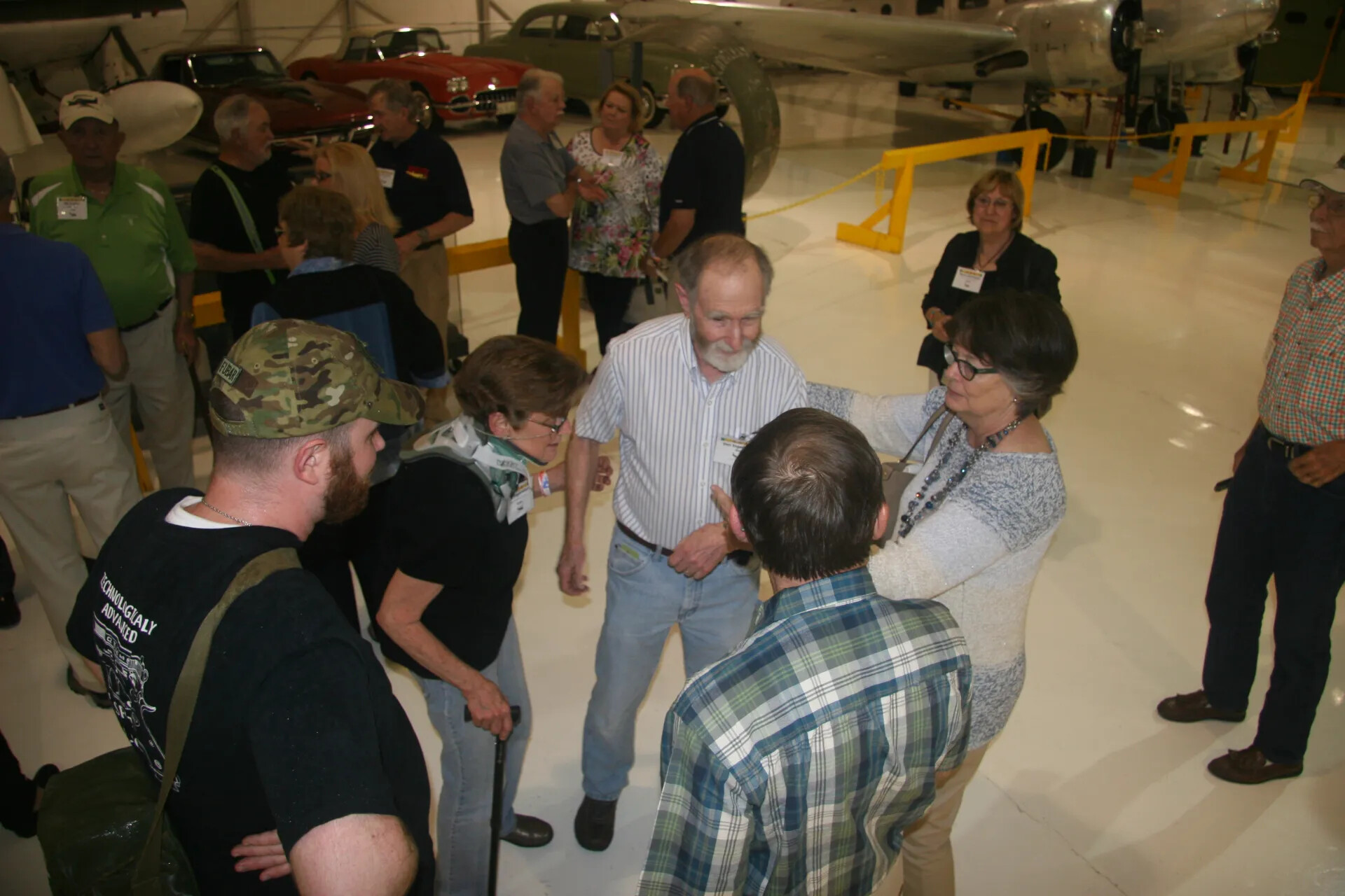 Crowd of Reunion Attendees Mingling in Aviation Museum Hangar