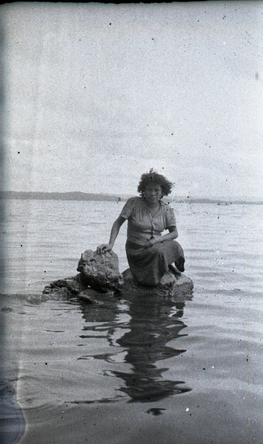 Woman Kneeling on Rock in Shallow Water, Luzon, Philippines, WWII Era