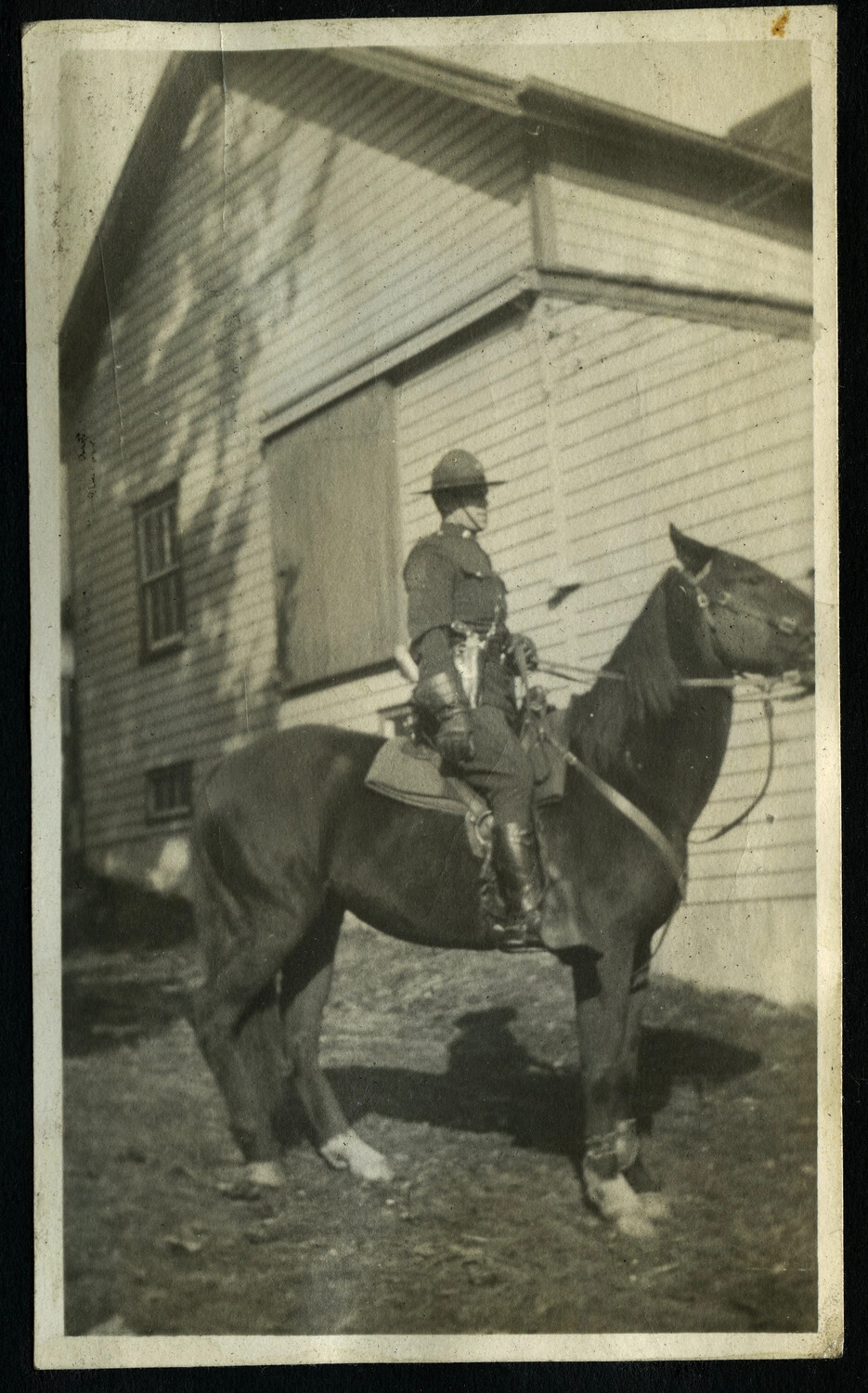 Mounted Police Officer (or Cavalryman) on Horseback Beside a Stable, c. WWI Era