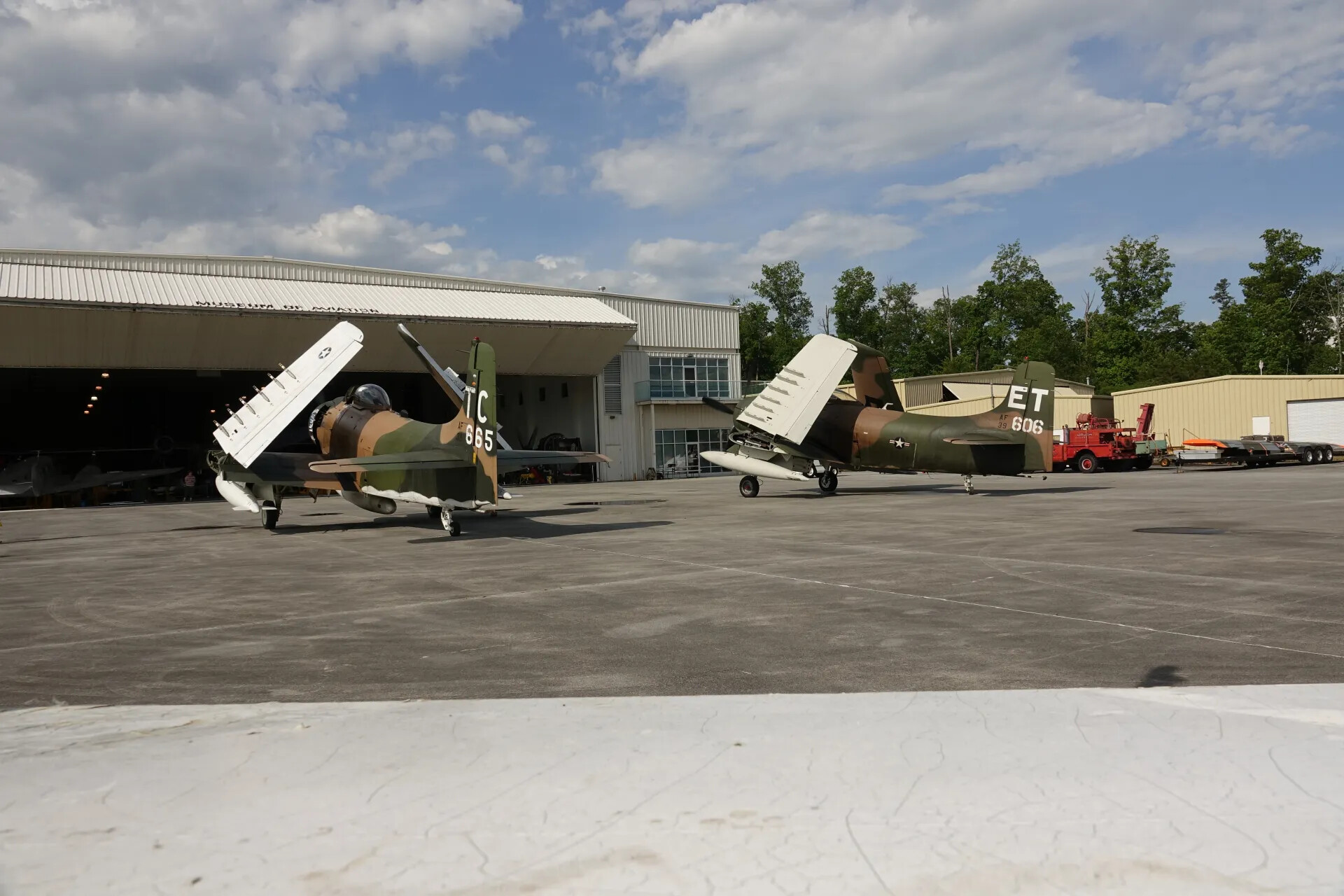 Two Douglas A-1 Skyraiders, Wings Folded, Parked at Museum Hangar (Alternate Angle)