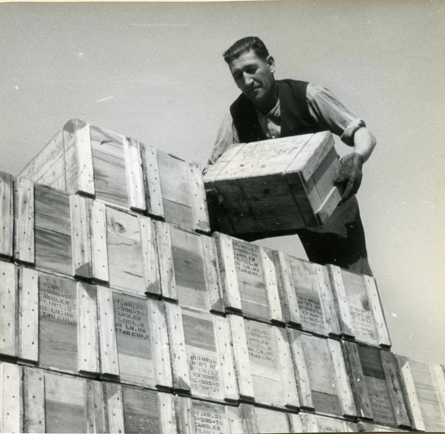 Warehouseman Stacking Crates of Candles, Close Detail View