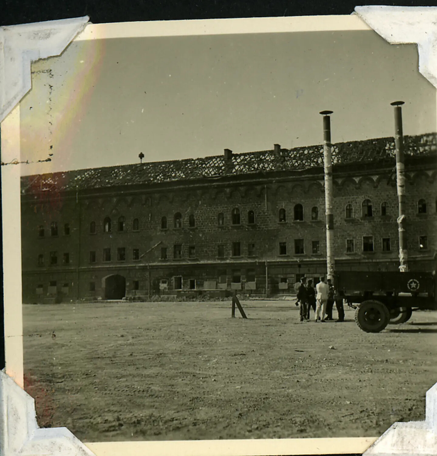 US Army Personnel and Cargo Truck Before a War-Damaged European Barracks Building