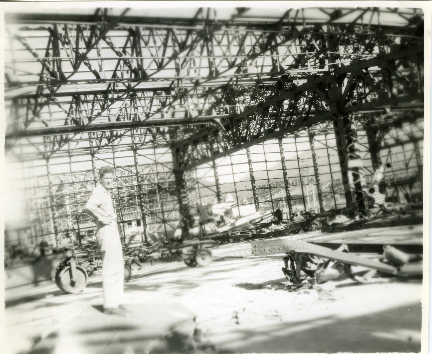 Serviceman Amid Wreckage in Bombed-Out Aircraft Hangar, Pacific Theater, WWII