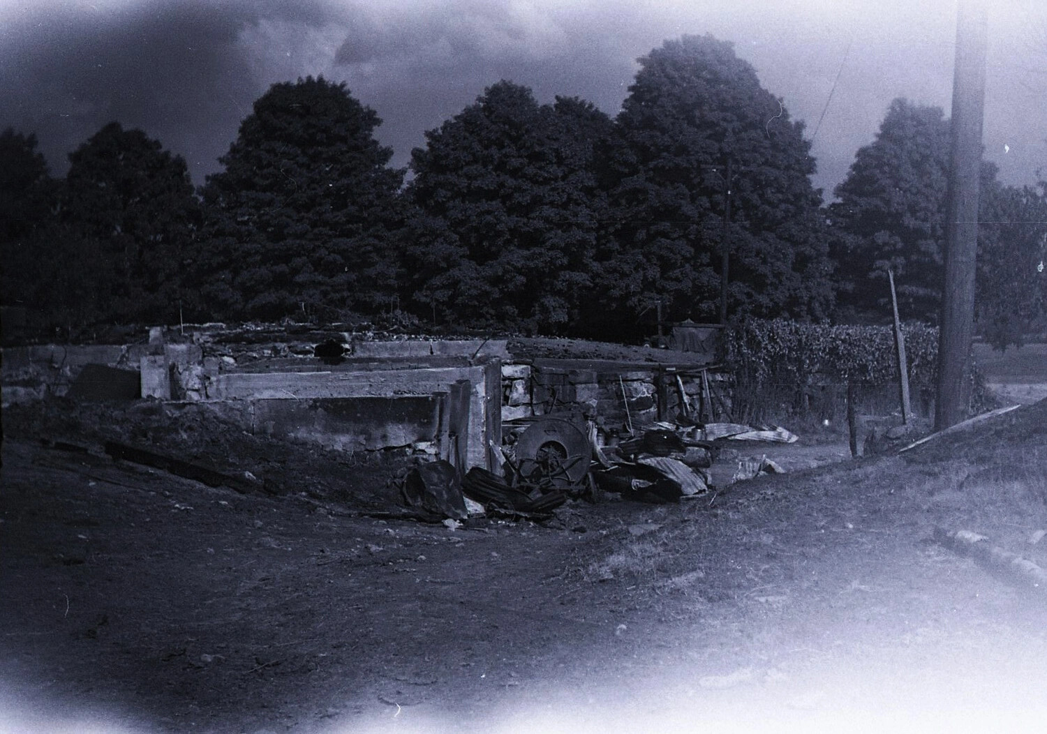 Fire-Destroyed Dairy Barn Foundation with Collapsed Roofing, Rural New England, c. 1940s