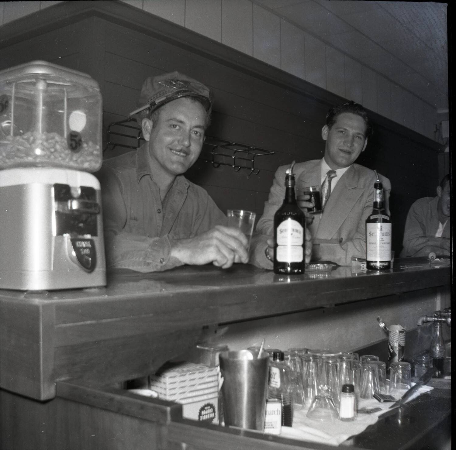 Two Patrons at a Bar Counter with Seagram's Whiskey Bottles, Early 1950s