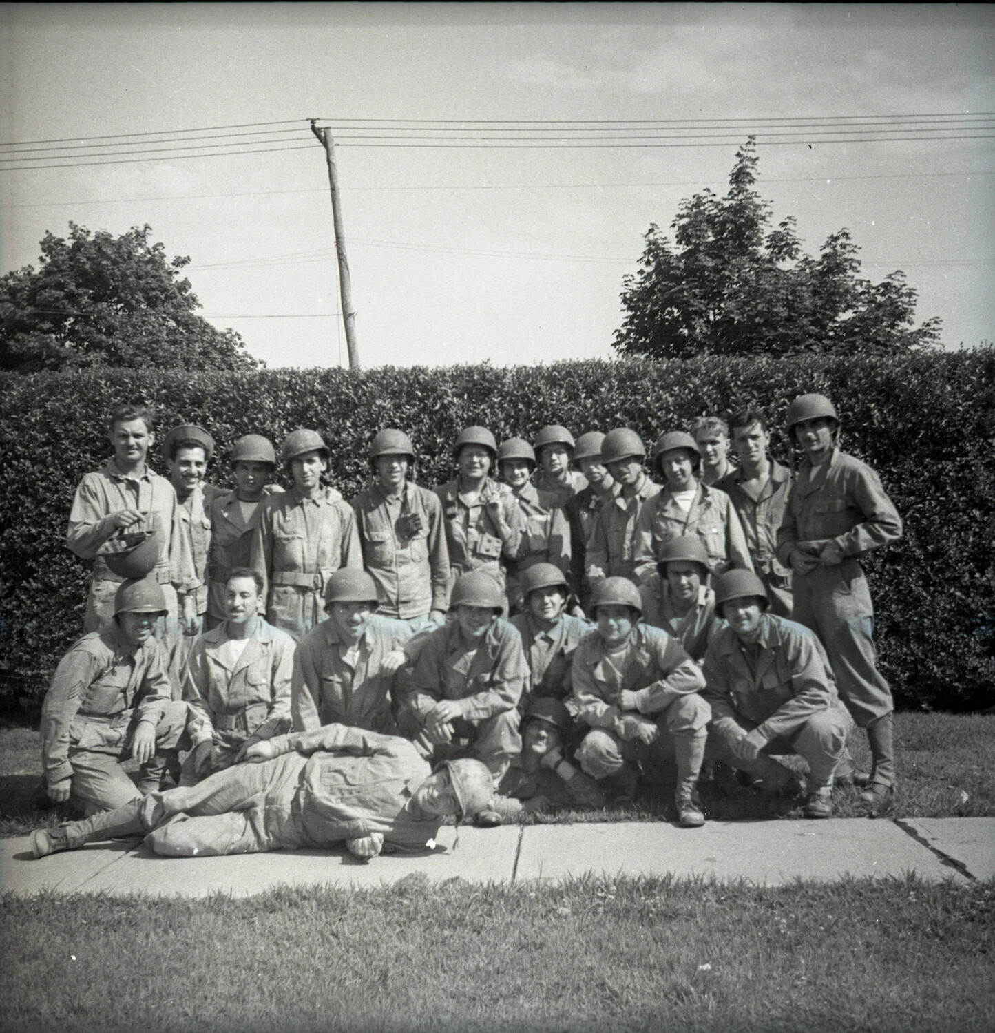 Group Portrait of Servicemen in Field Uniform, with Comrade Feigning Collapse