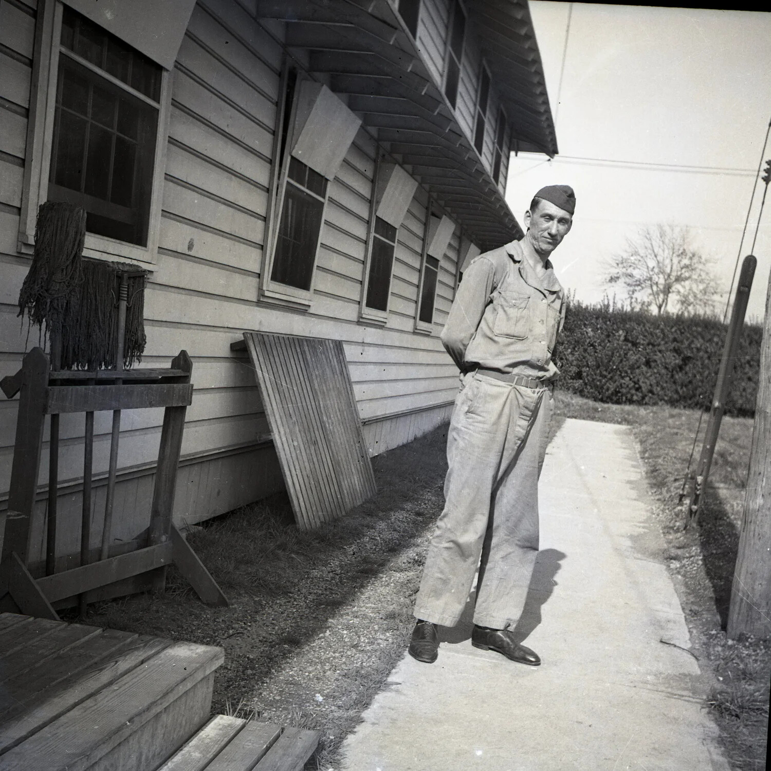 American Serviceman Beside Barracks Building, WWII-Era Training Camp