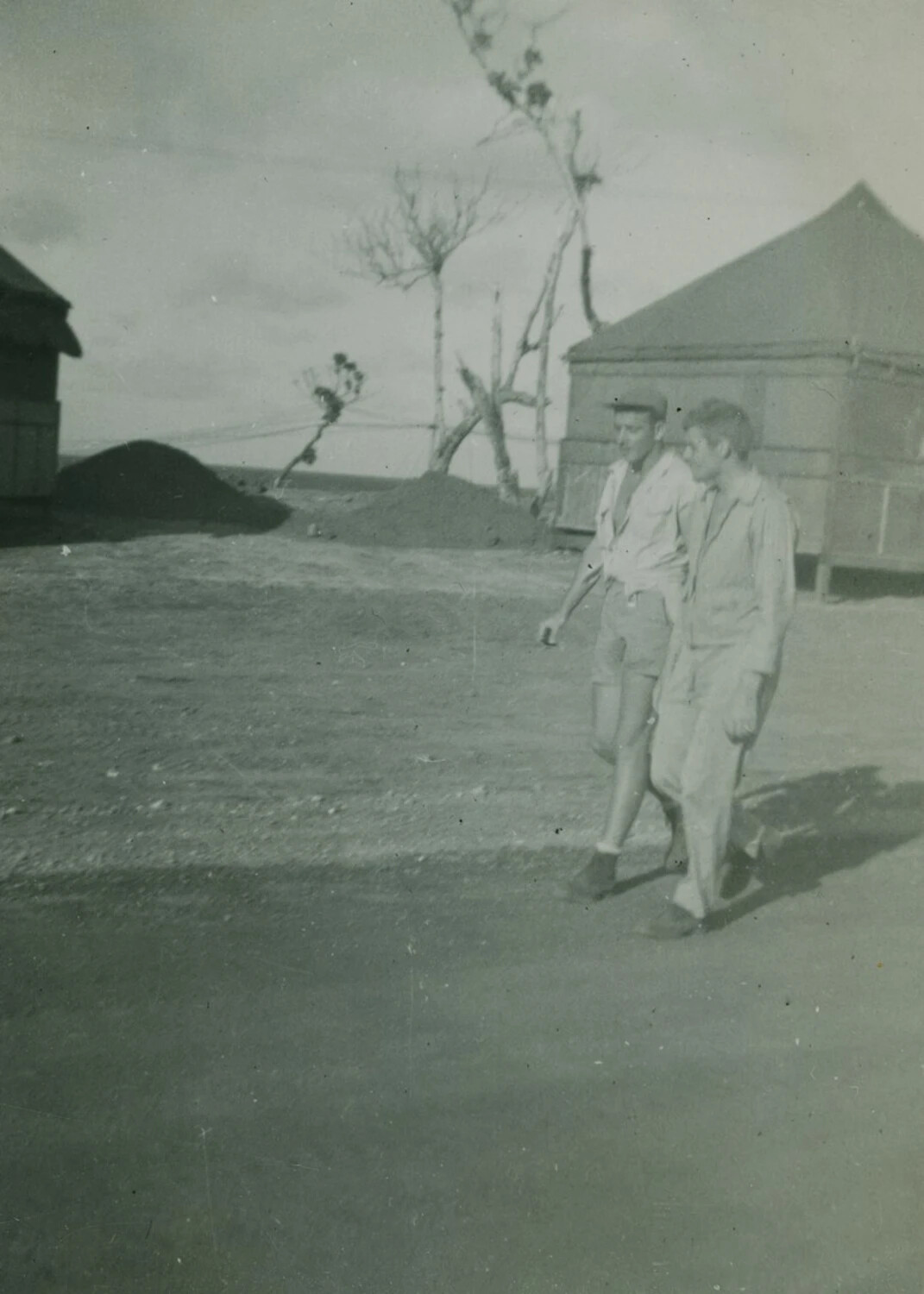 Two Servicemen Walking Through a Military Camp Area, WWII-Era Snapshot