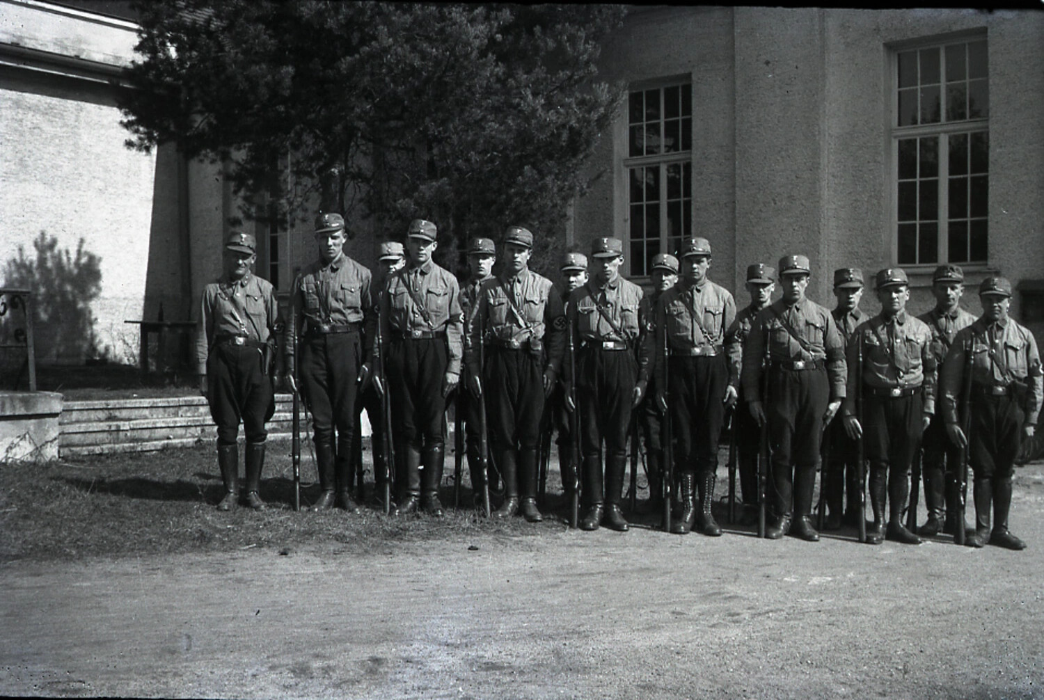 Formation of Sturmabteilung (SA) Members in Ranks Outside a Stuccoed Building