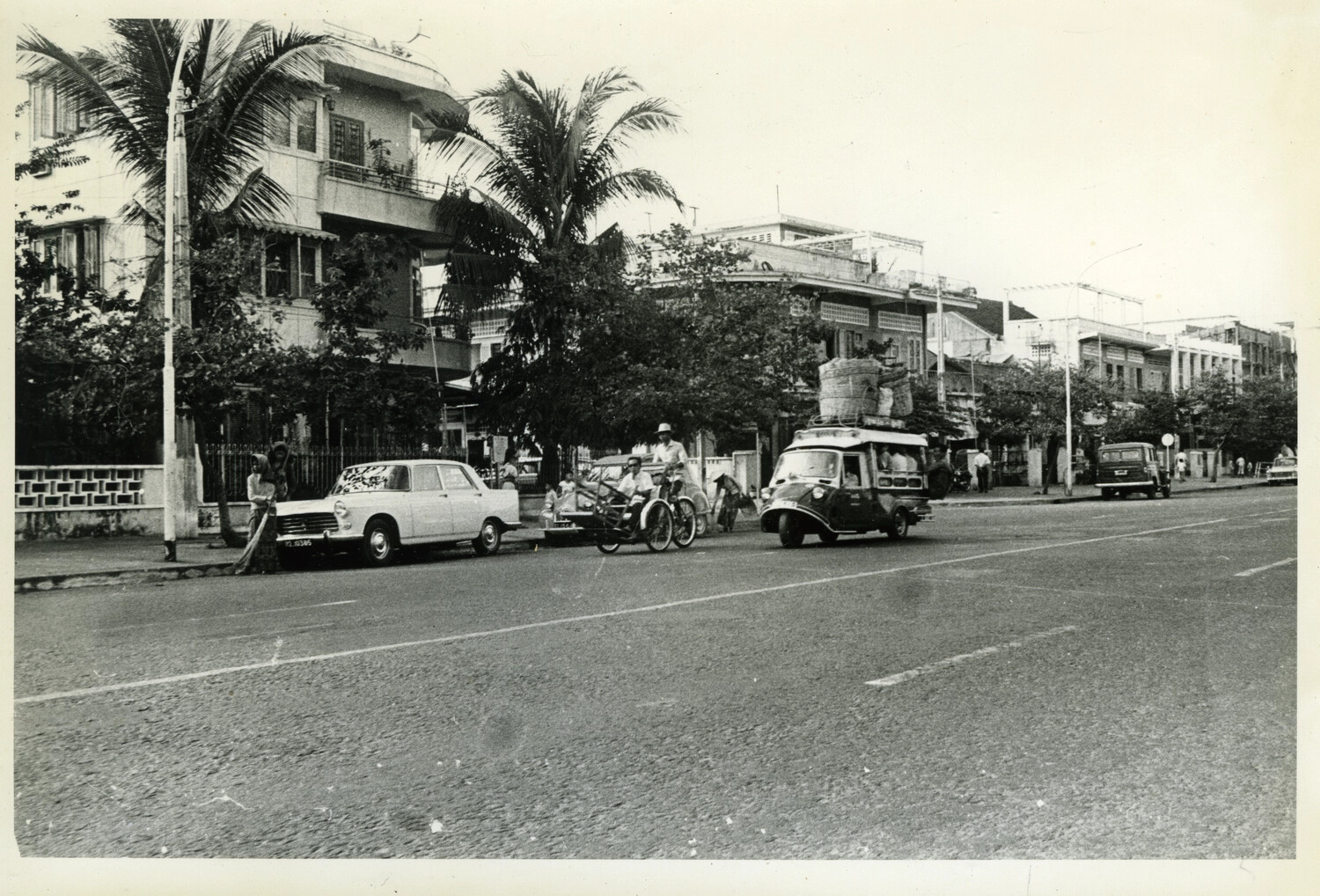 Loaded Three-Wheeled Taxi and Cyclo Traffic on Palm-Lined Street, Phnom Penh, Cambodia, c. 1960s
