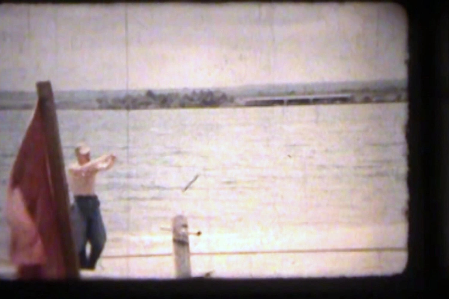 Sailor Throwing Knife at Target Post, NAS Kaneohe Bay, Hawaii (Korean War Era Home Movie Still)