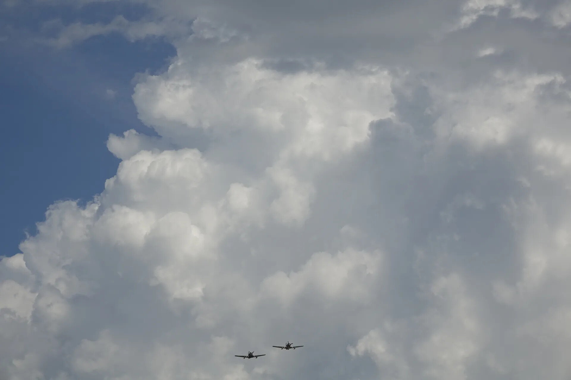 Formation Flight of Two Warbird Aircraft Beneath Cumulus Clouds, 2019 Commemorative Event