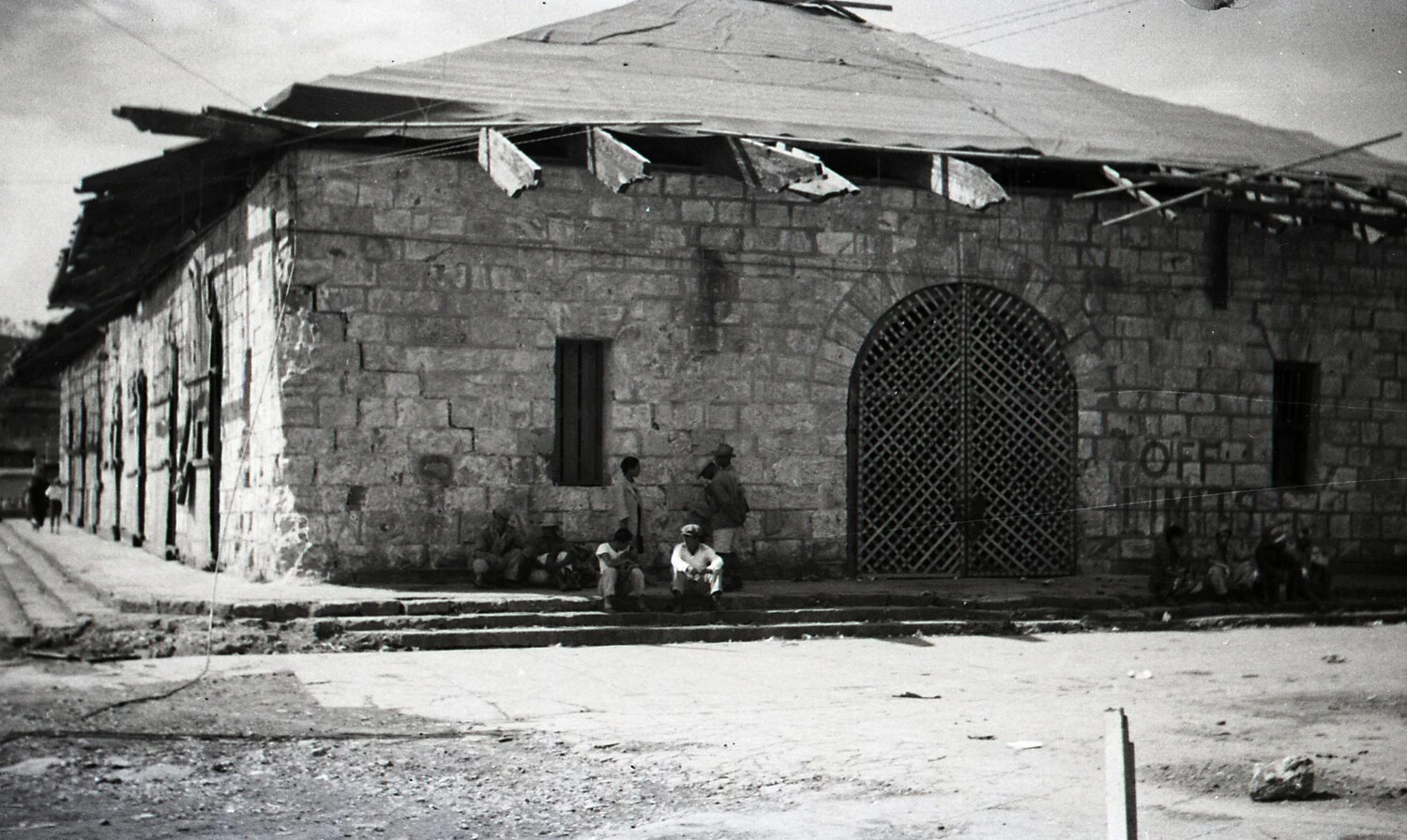 Damaged Stone Building with Arched Gate and Painted Signage, Likely Baguio, Luzon, Philippines, WWII Era
