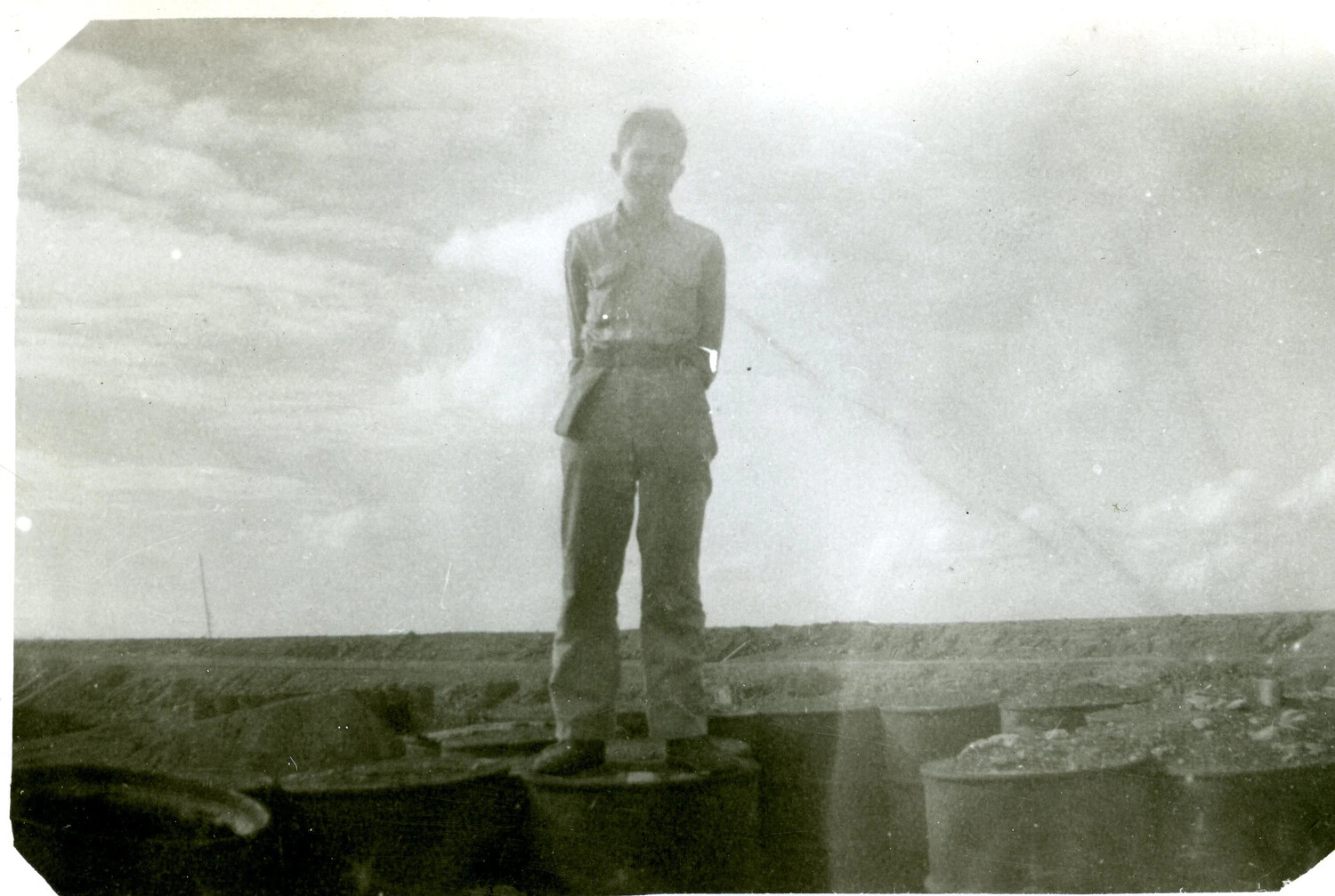 Marine Posing on Stacked Fuel Drums, Iwo Jima, 1945