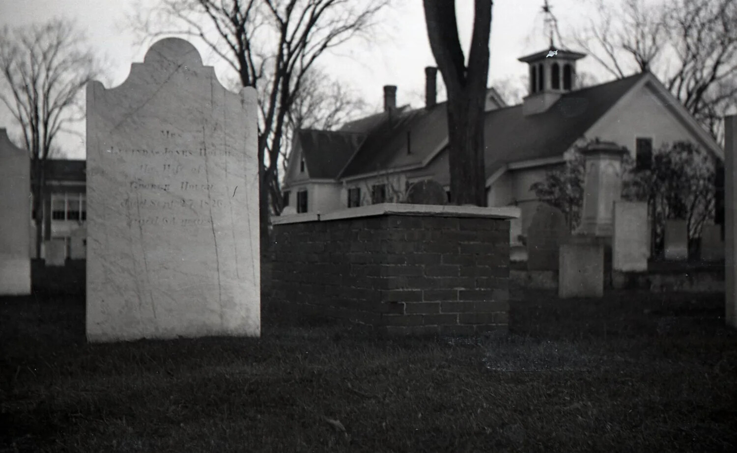 Weathered Headstone and Brick Tomb Before Colonial Meeting House, New England Burying Ground