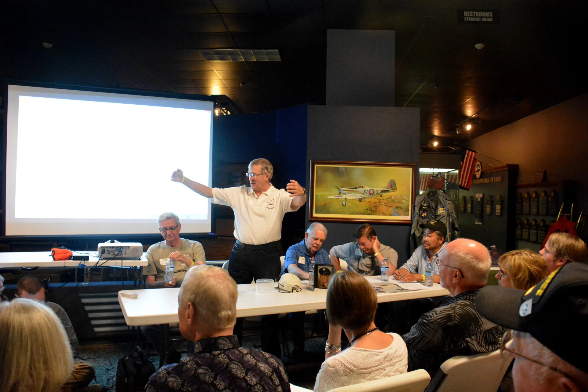 Veterans' Reunion Meeting, Aviation Museum — Speaker Gesturing During Presentation