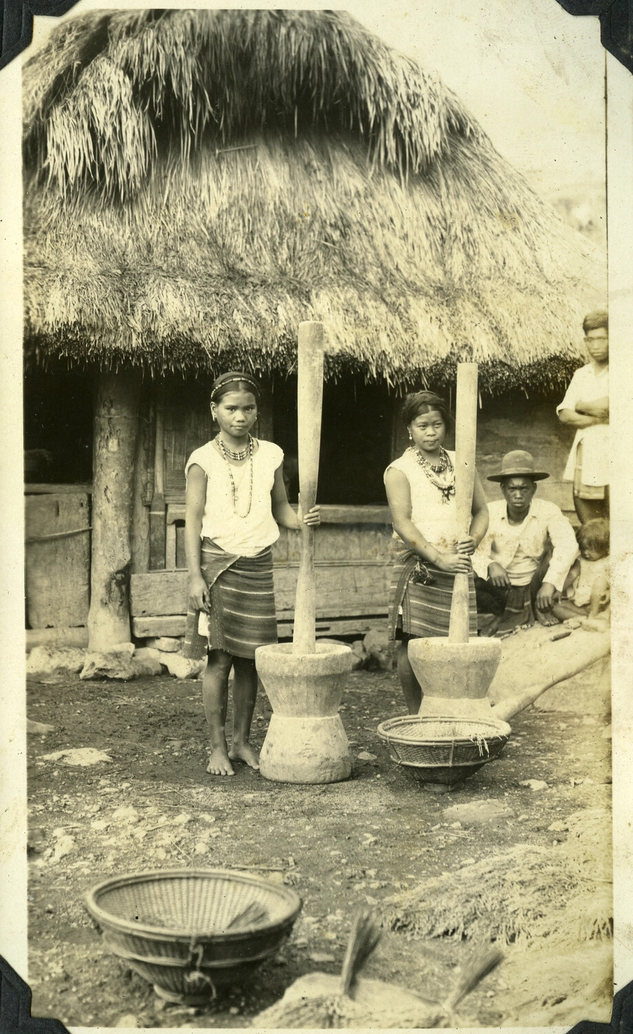 Filipino Women Pounding Rice at a Nipa Hut, Philippines (Manila Photo Album, WWII Era)