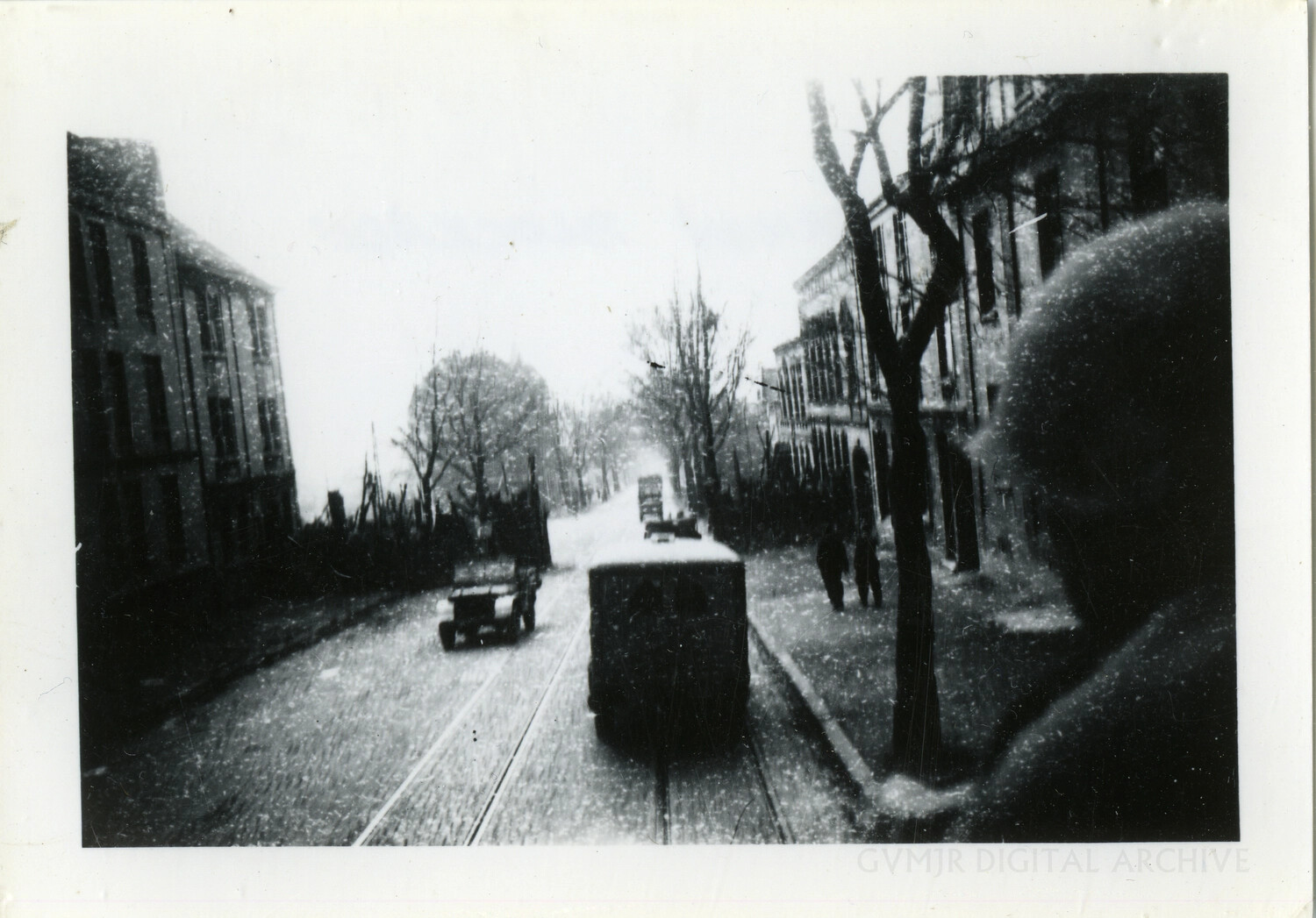 Snowbound Town Street with Tram and Jeep, Photographed from a Moving Vehicle — Belgium, Winter 1944-45