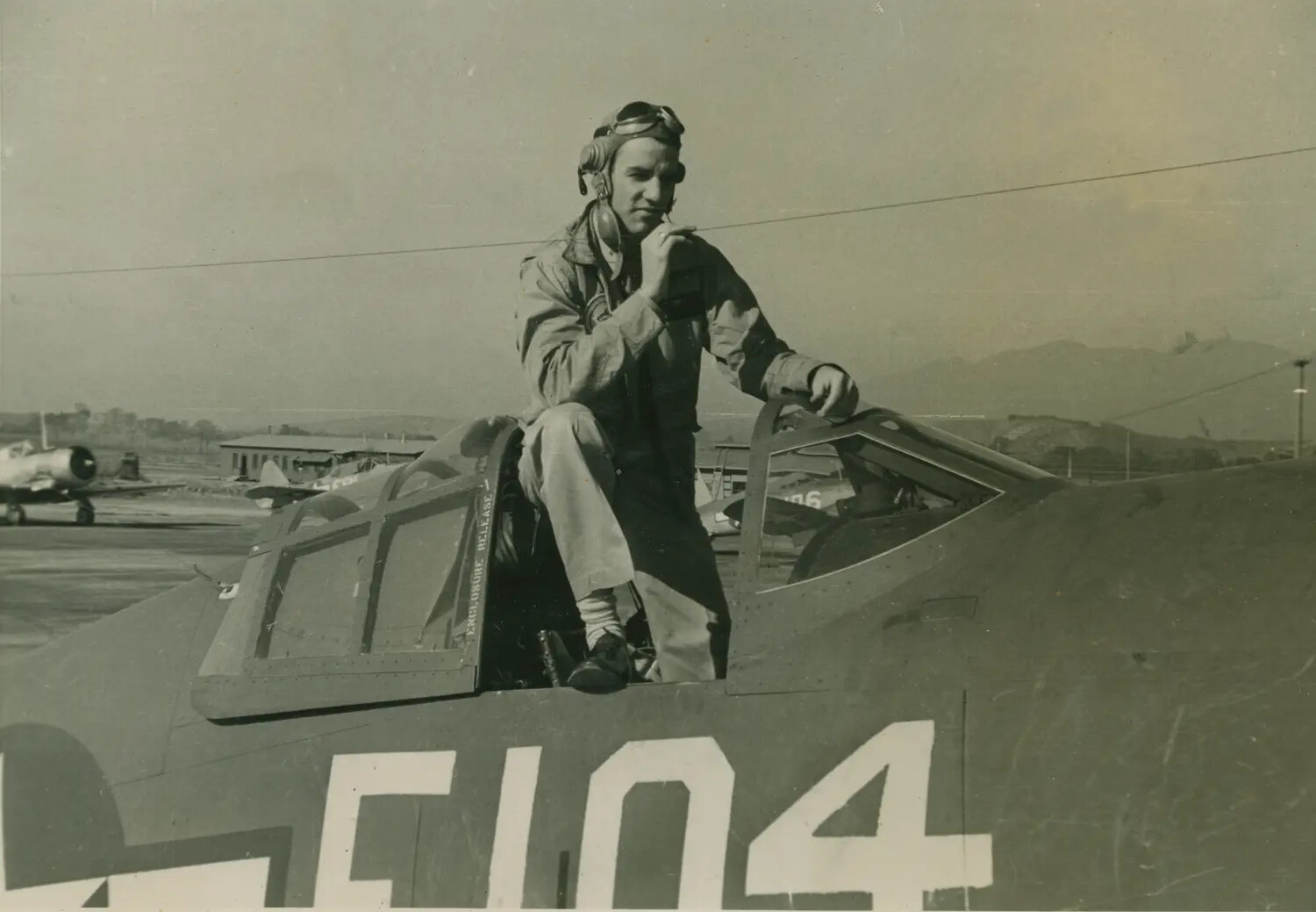 Fighter Pilot Standing in Cockpit of Aircraft 'F104,' Korean War Era