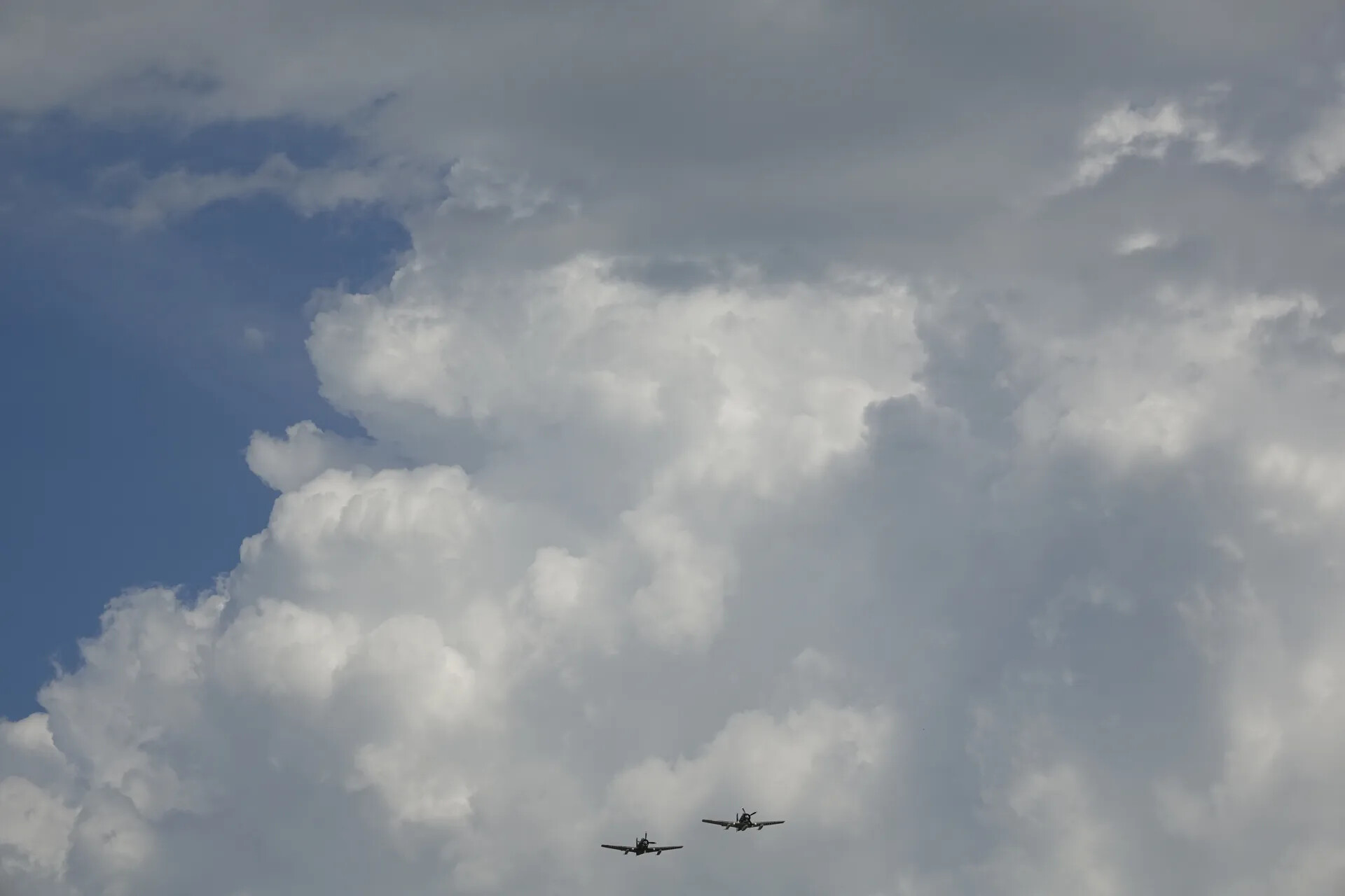 Two Aircraft in Formation Beneath Cumulus Clouds, May 2019 Reunion Event
