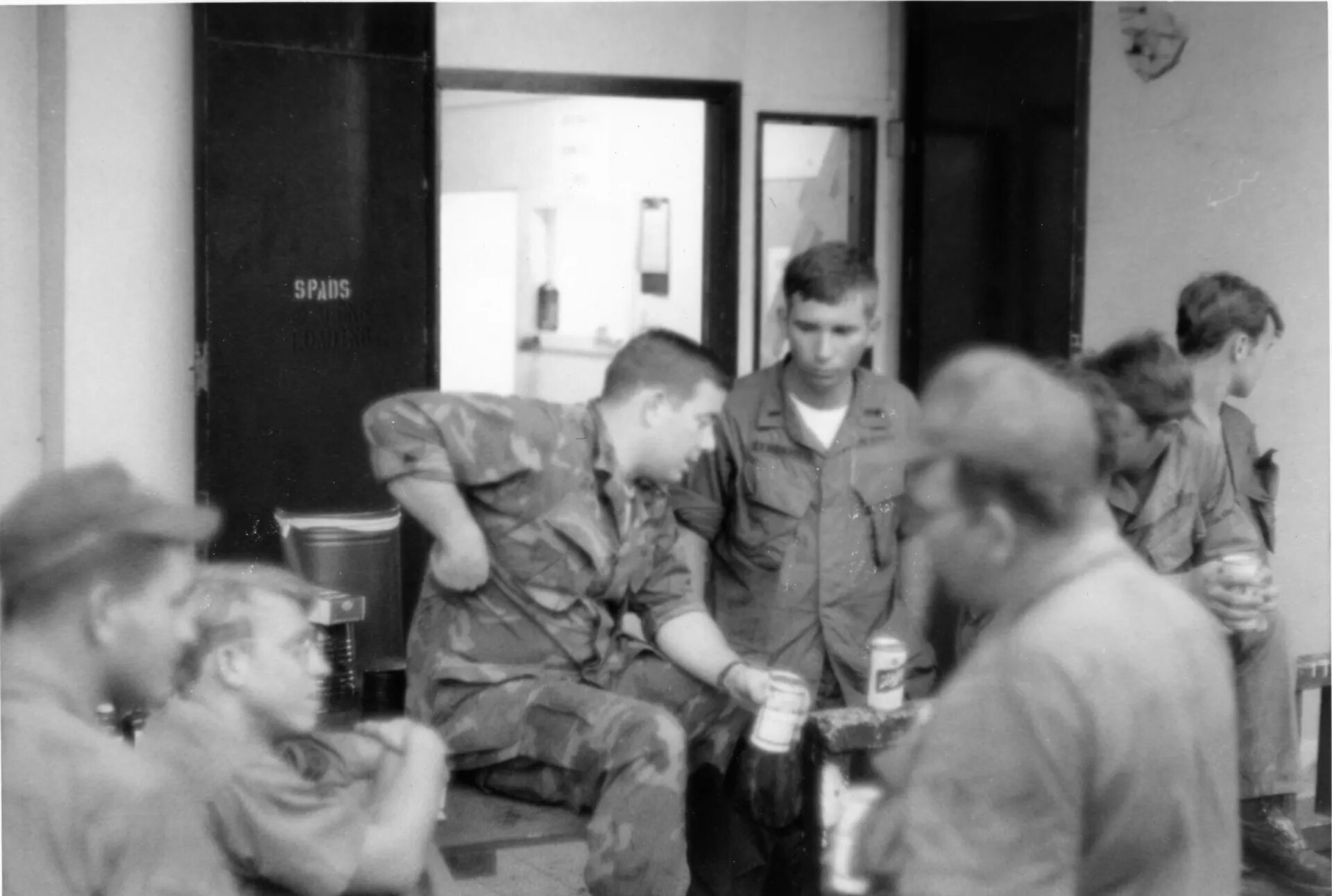 Off-Duty Airmen Gathered Beside "SPADS" Marked Crate, Vietnam-Era Squadron Building