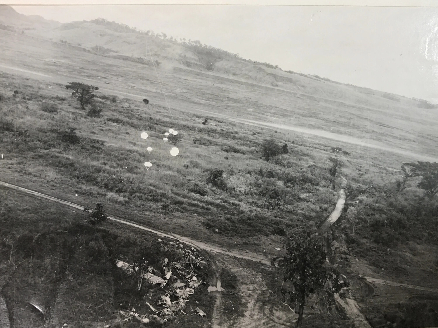 Parafrag Bombs Descending Over Hillside Dispersal Terrain