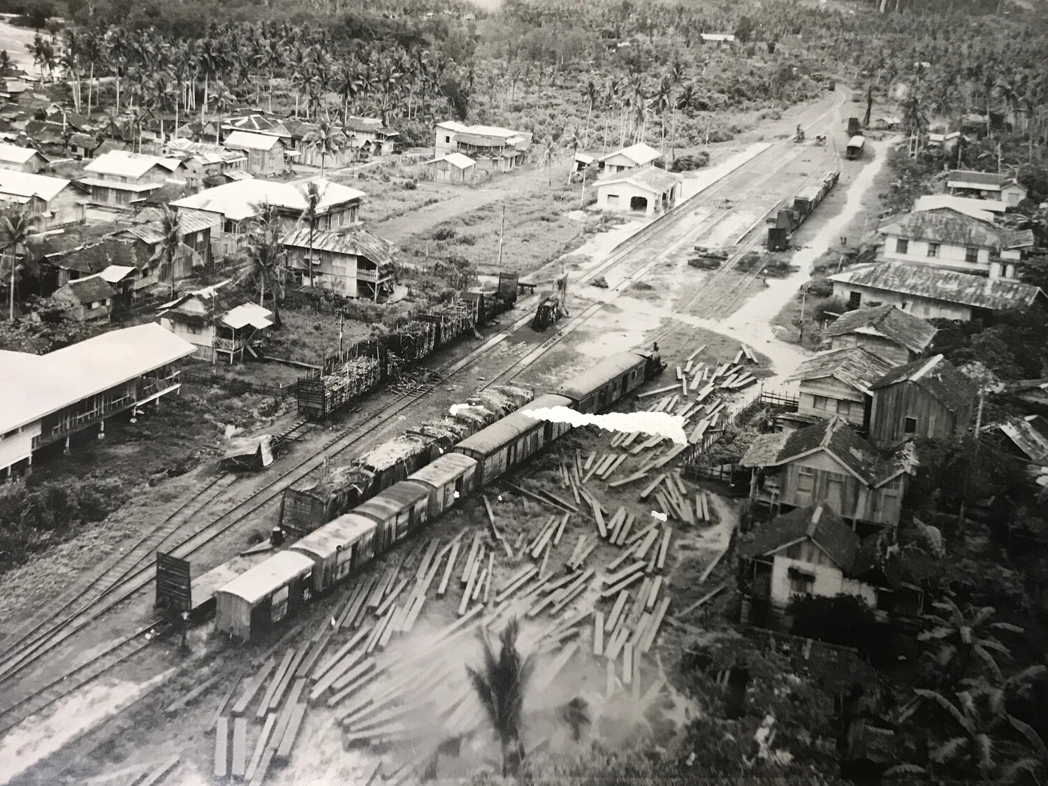 Aerial View of Rail Yard with Boxcars and Lumber Stockpiles, Philippine Rail Town