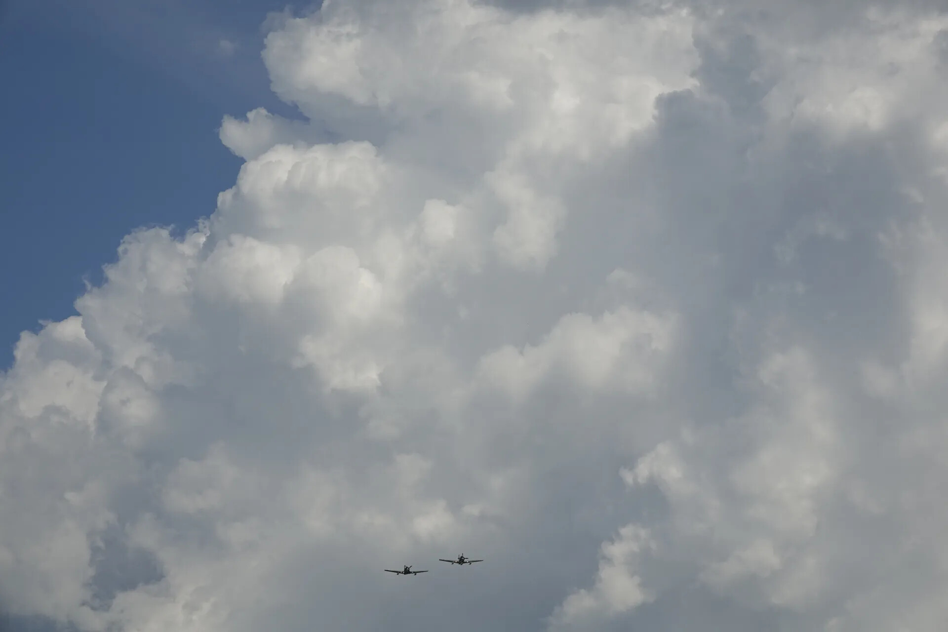 Two-Ship Warbird Formation Beneath Cumulus Clouds (Sequence Frame)
