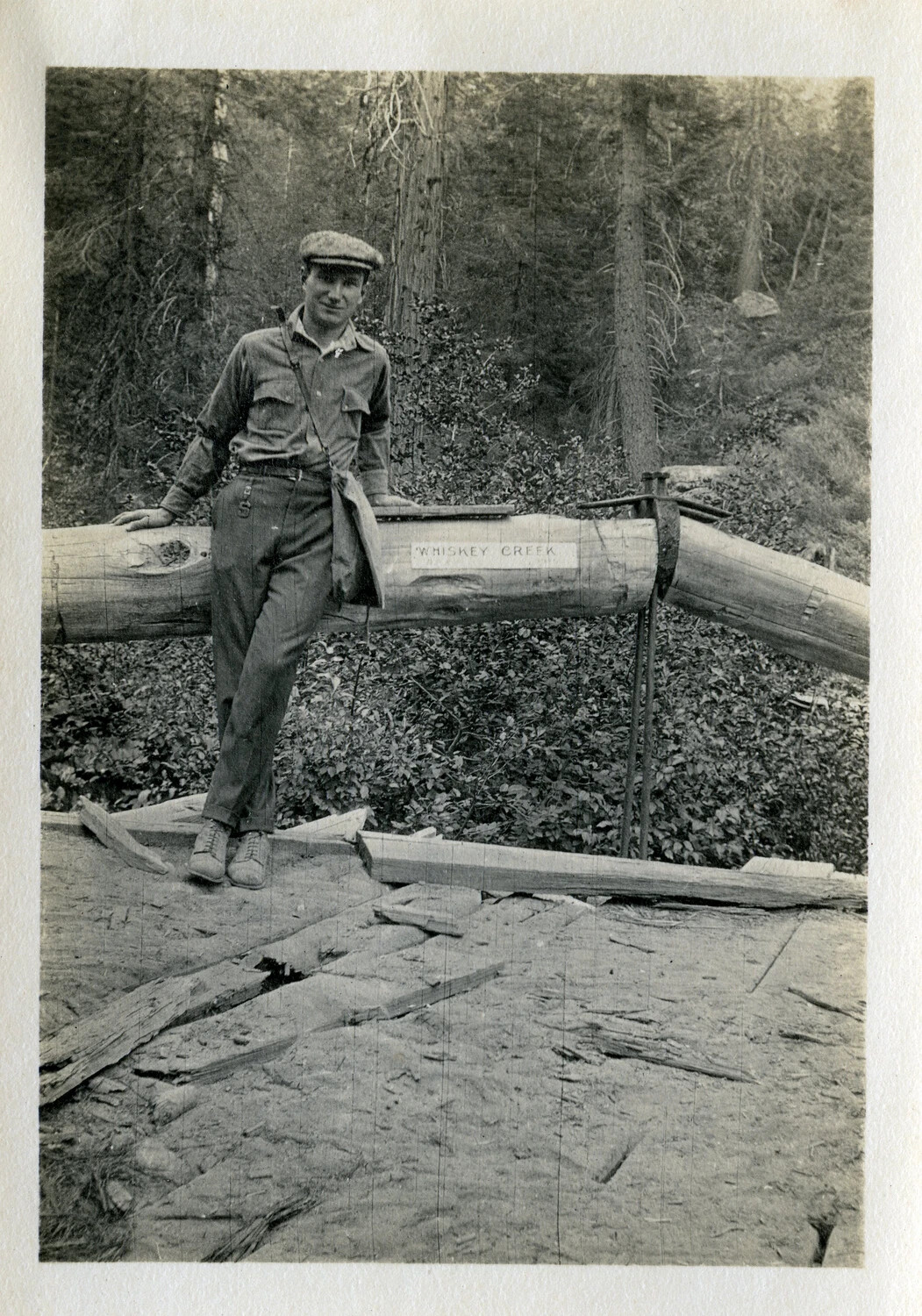 Man Posing on Log at "Whiskey Creek" Logging Site, 1921