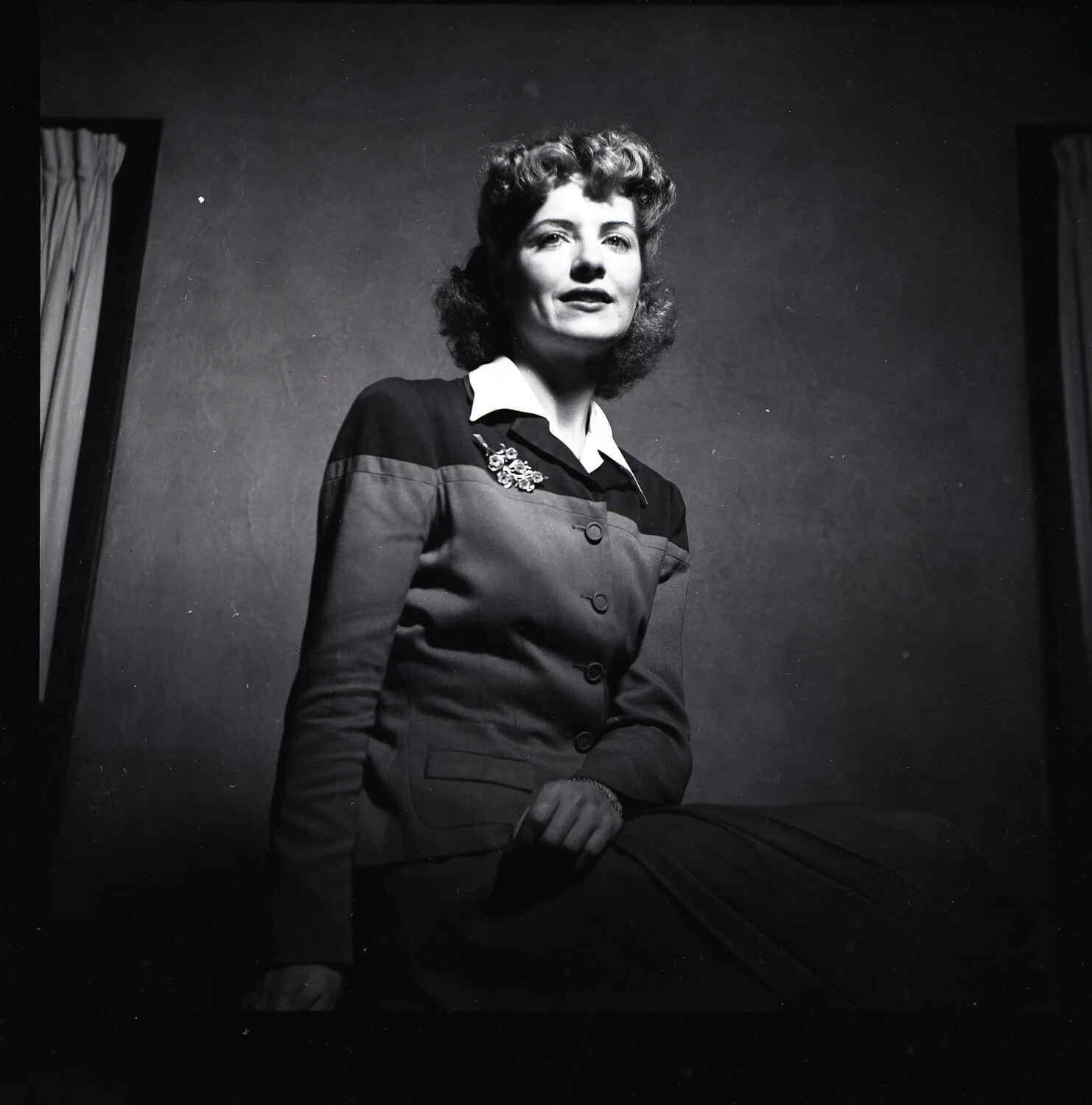 Studio Portrait of a Young Woman in Tailored Suit with Brooch