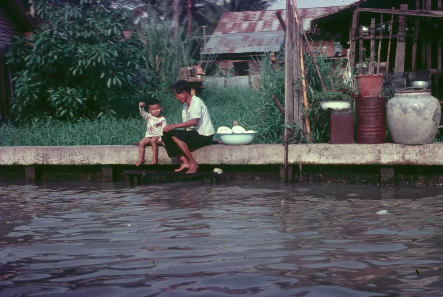 Vietnamese Woman and Child at Canal-Side Dwelling, 1965, 3rd Tactical Fighter Wing Collection