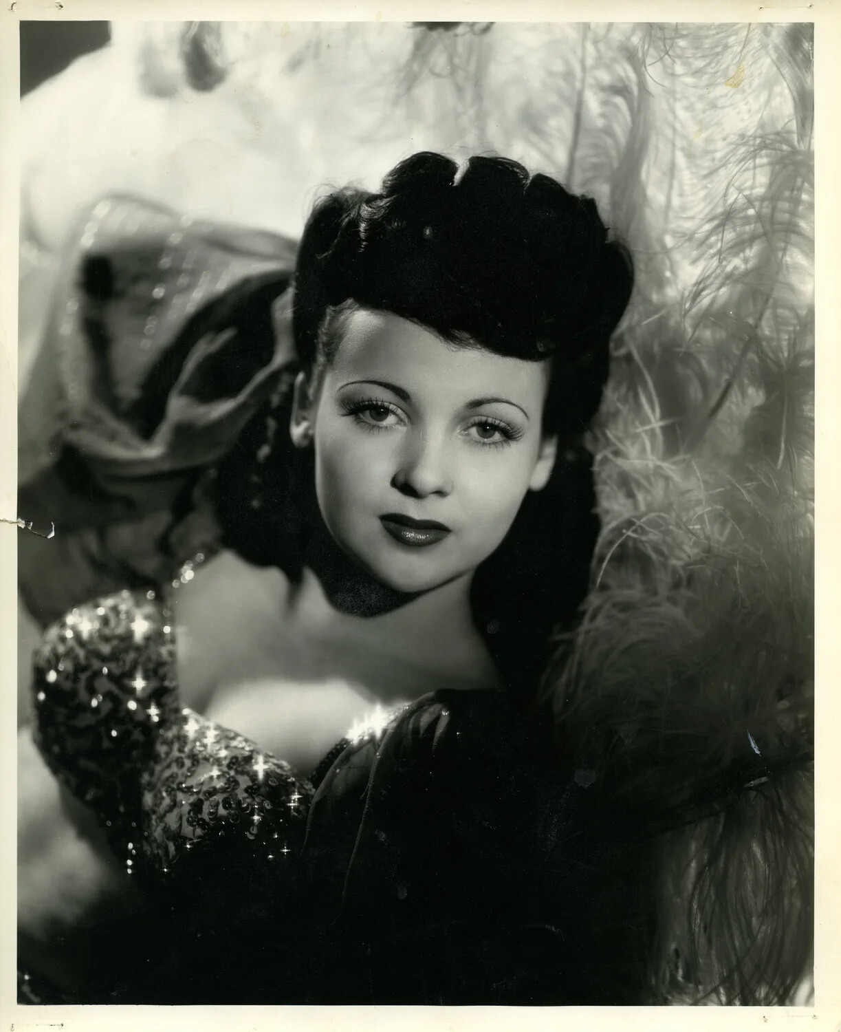 Studio Glamour Portrait of a Woman in Sequined Bodice with Feather Backdrop, c. 1940s