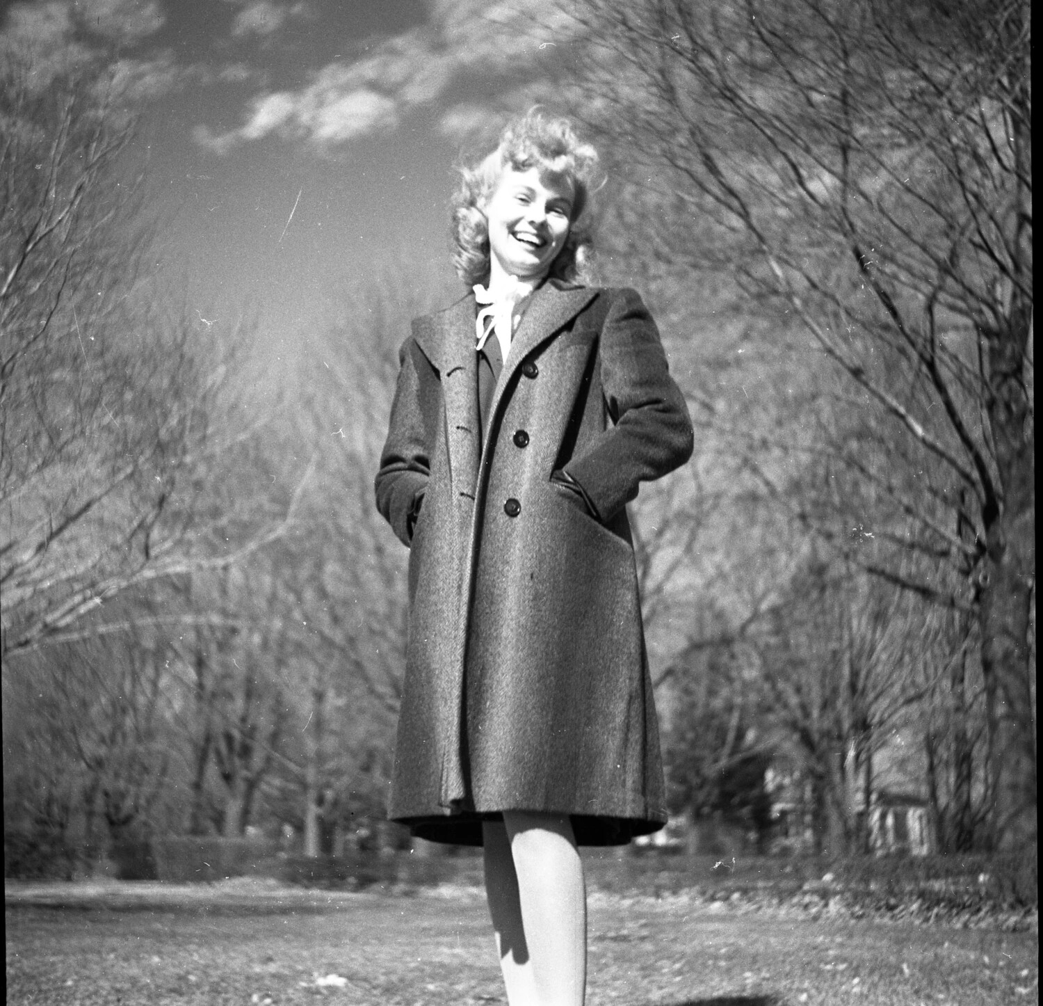 Young Woman Laughing Outdoors in Wool Overcoat - Park Setting, Winter/Early Spring