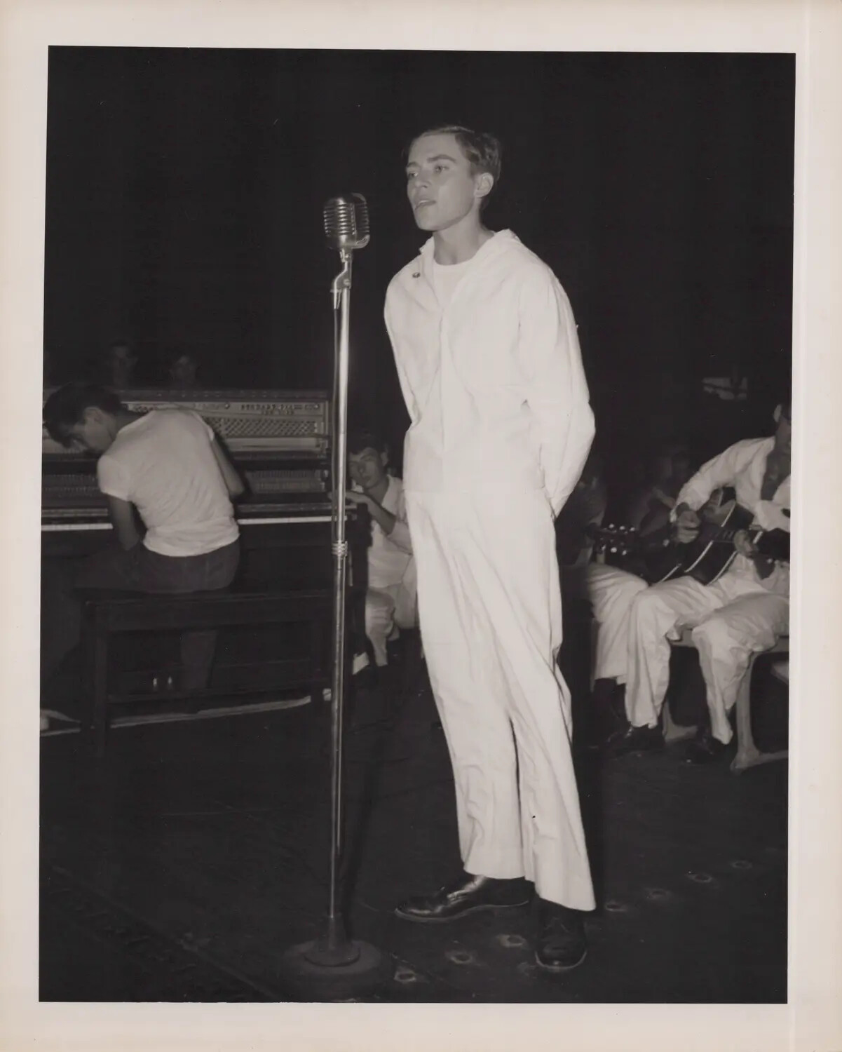 Shipboard Talent Show: Sailor Vocalist Performing with Band Aboard a U.S. Navy Escort Carrier, WWII