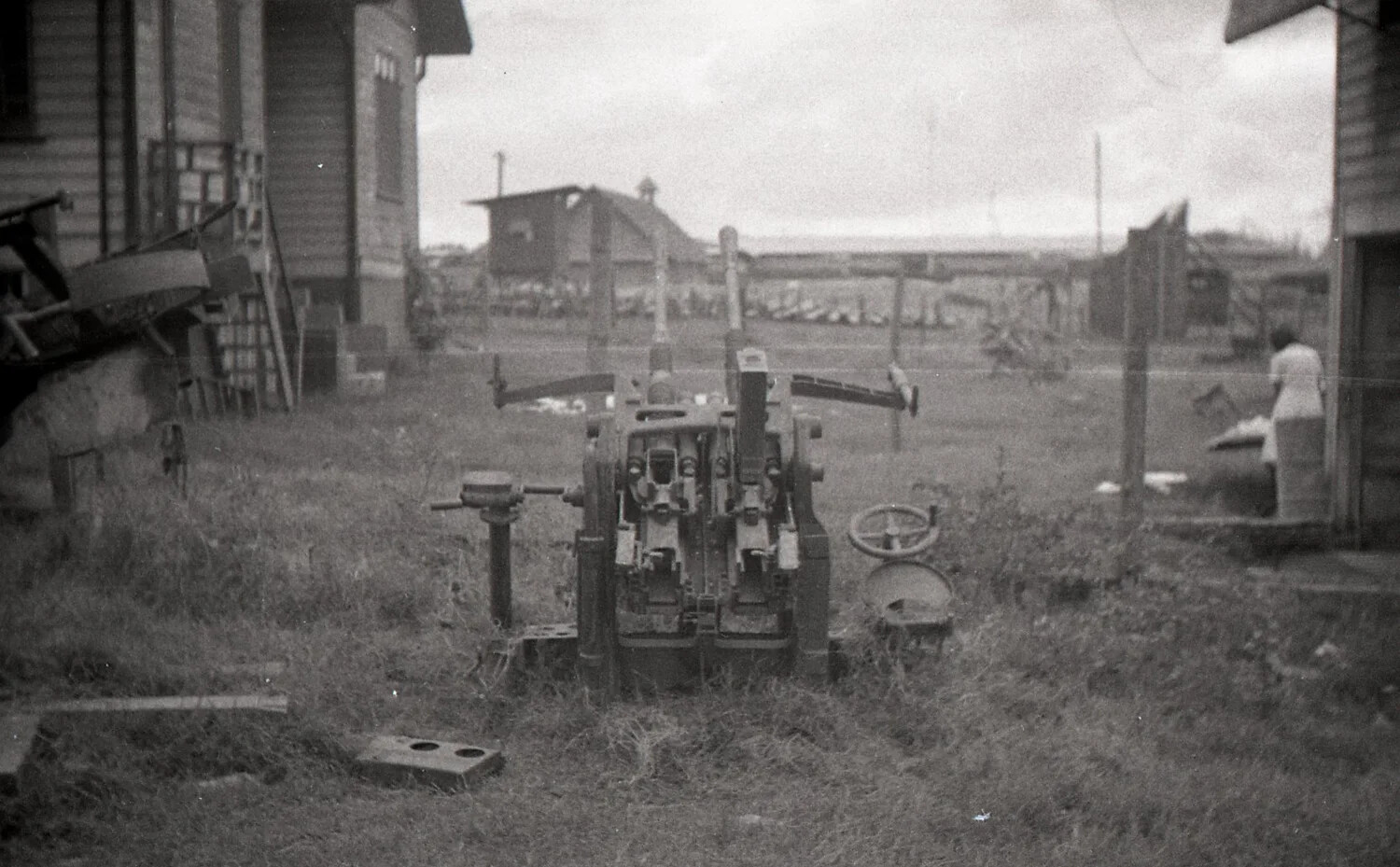Twin-Barreled Anti-Aircraft Gun in Yard Setting, Wide View, Luzon, Philippines, WWII
