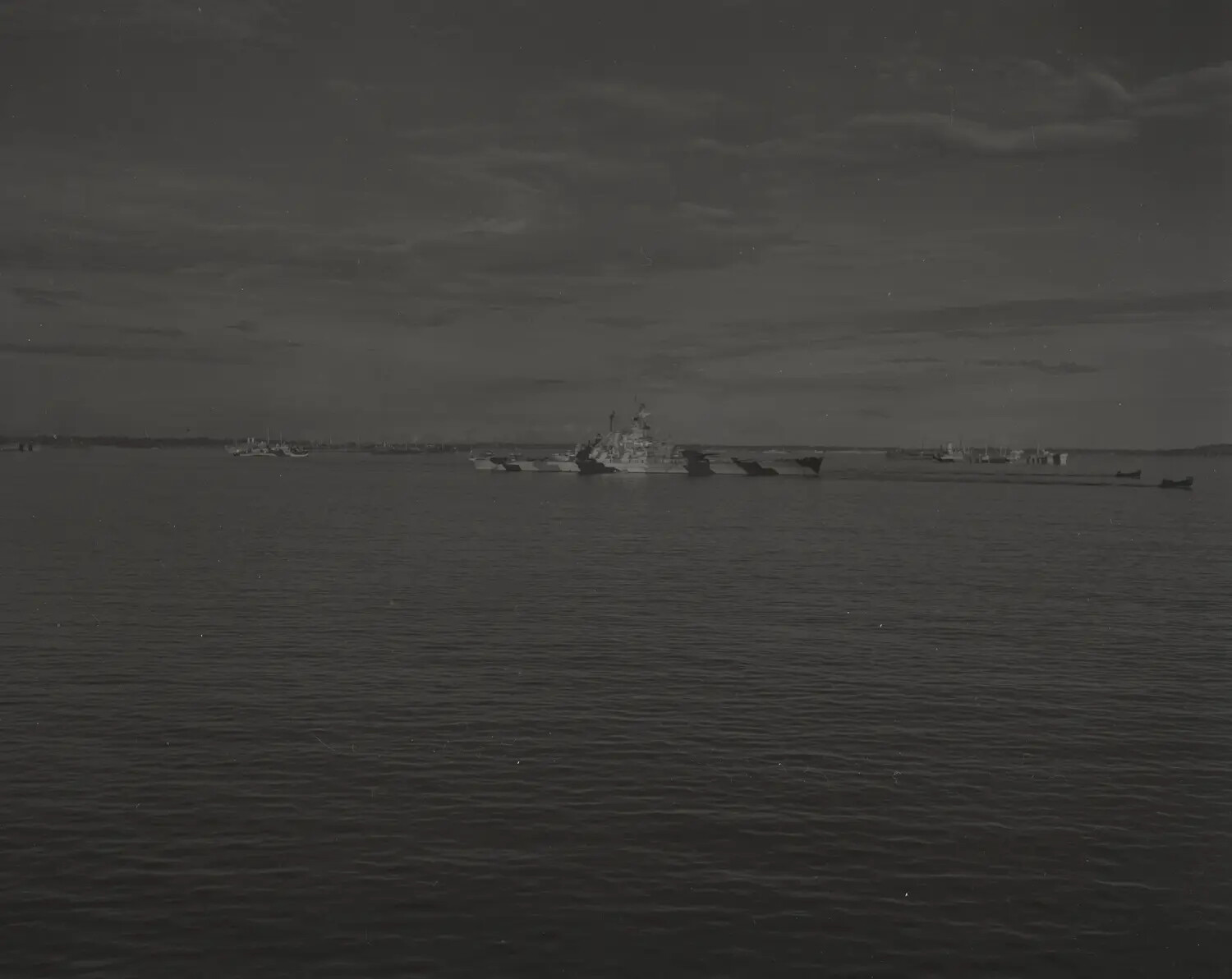 U.S. Navy Warship in Camouflage Paint Scheme Crossing Harbor Waters, WWII Era