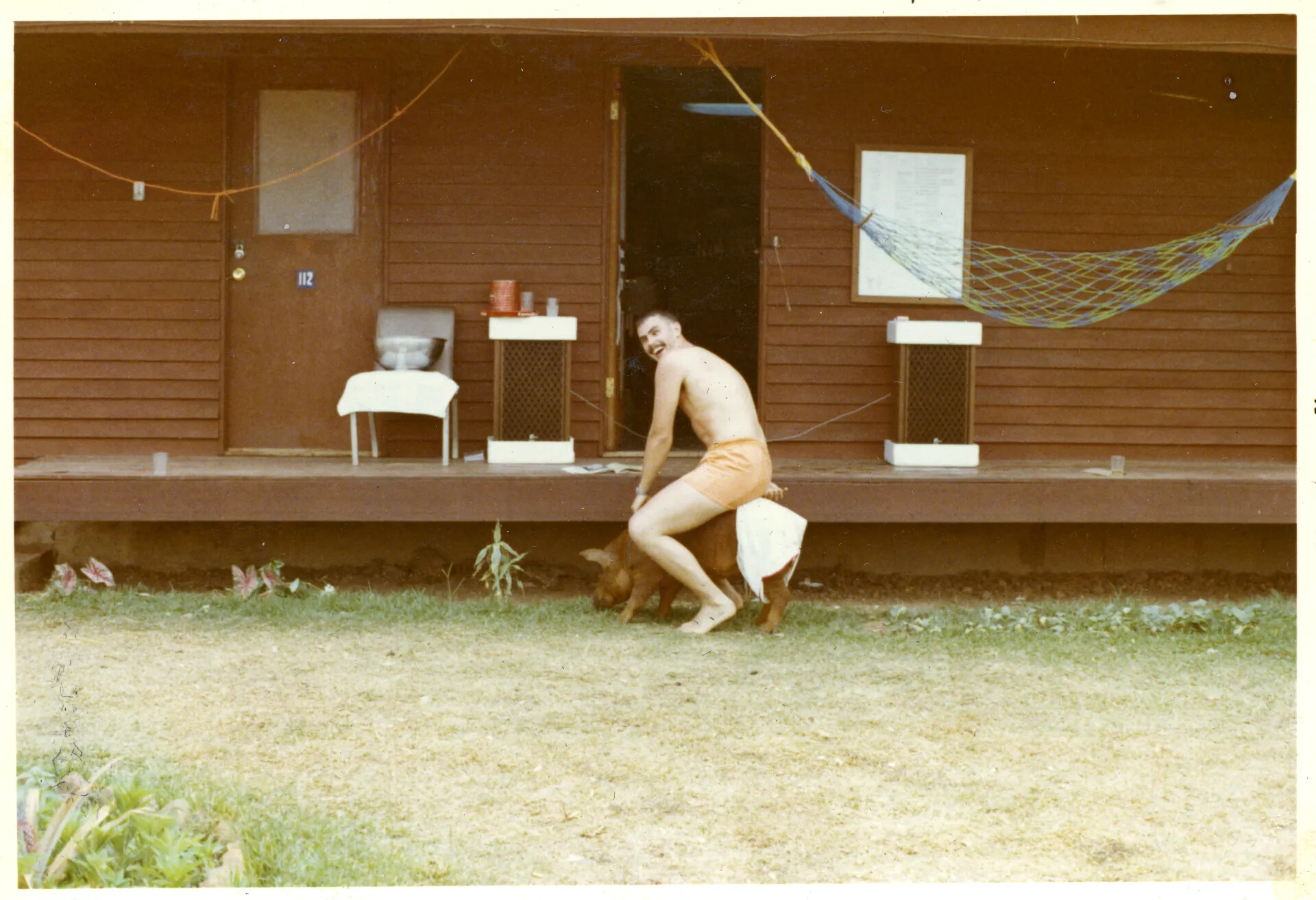 Airman Playing with Dog Outside Barracks, NKP, Thailand