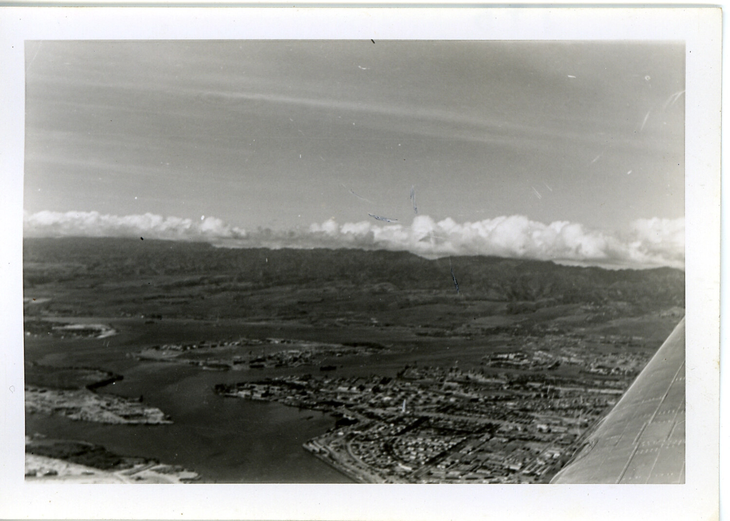 Aerial View of Oahu Harbor Inlet and Township with Aircraft Wing in Frame, Hawaii