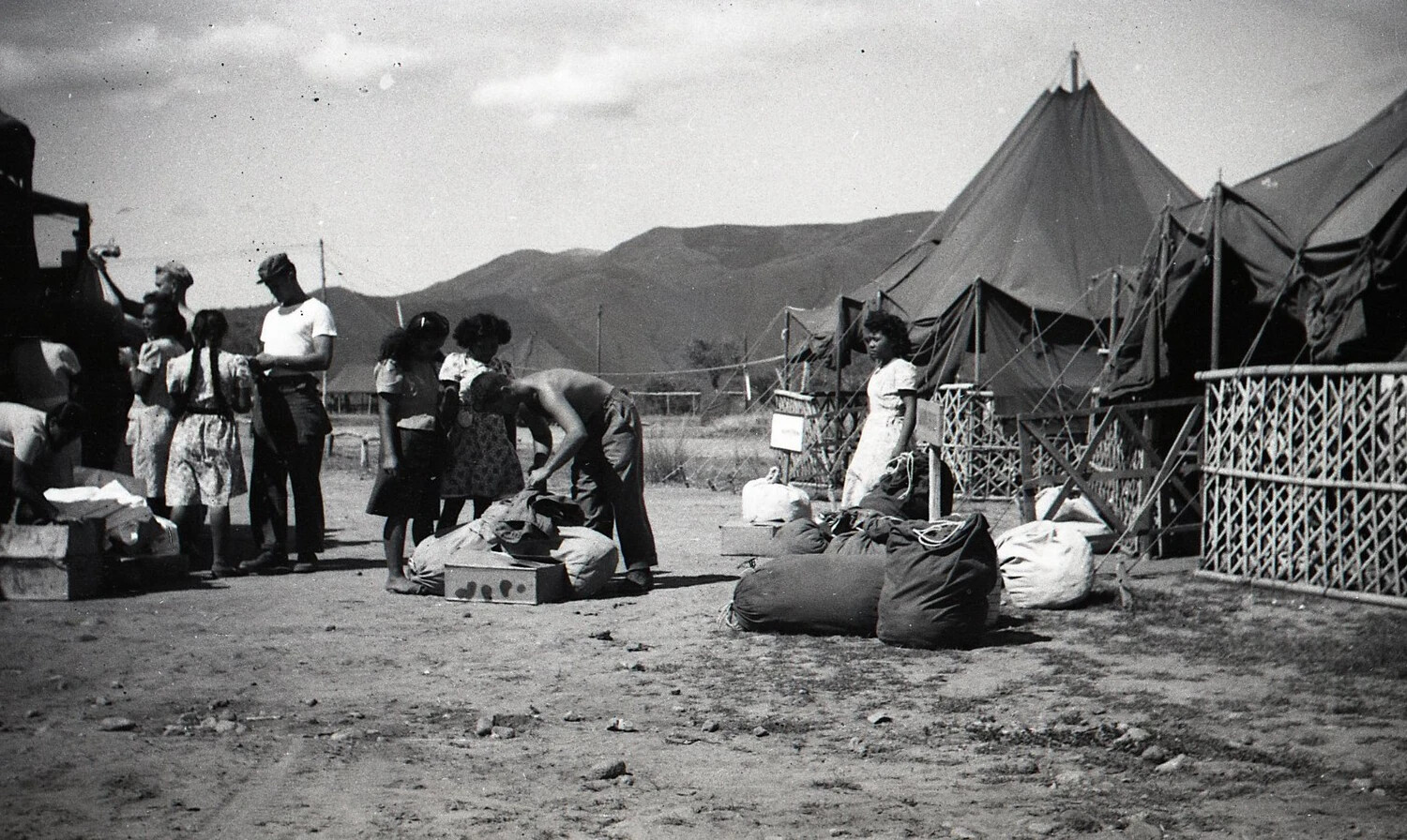 Filipino Civilians and American Serviceman at Tent Camp, Luzon, Philippines - WWII