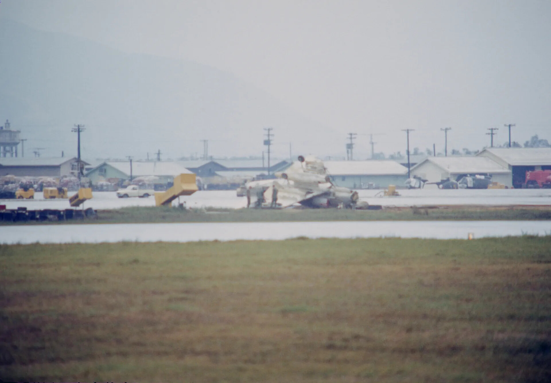 Wrecked Aircraft on Airfield Ramp Following Apparent Crash Landing, Southeast Asia