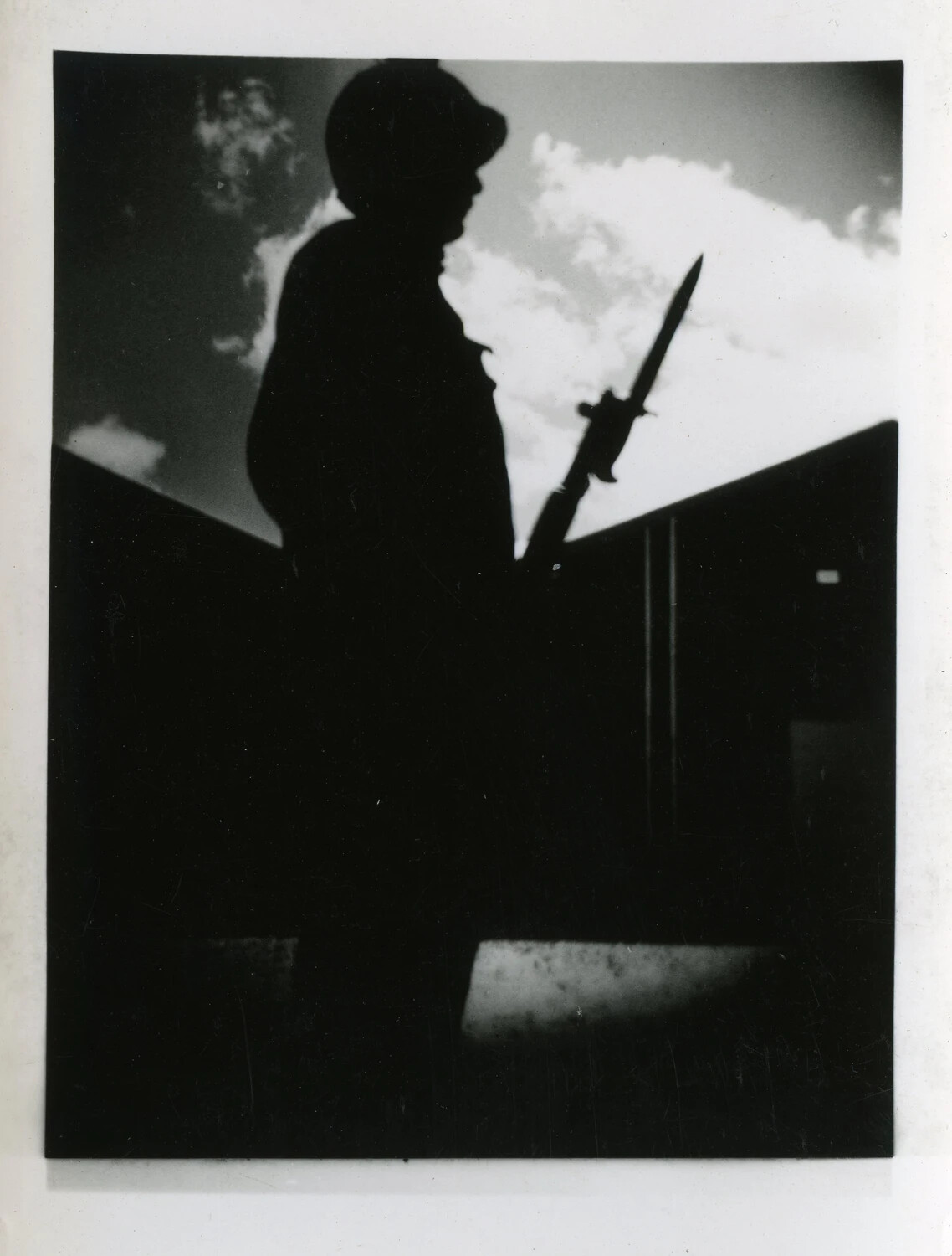 Silhouetted Sentry with Fixed Bayonet Against Cloudy Sky, World War II Era
