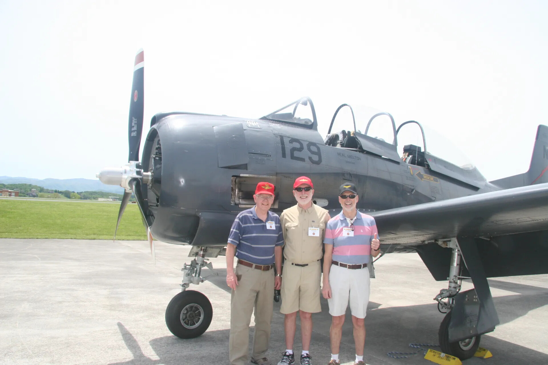 Veterans Posing with Thumbs-Up in Front of Preserved A-1 Skyraider-Type Aircraft 'Neal Melton' (No. 129), Tennessee Museum of Aviation Reunion Event, April 2016