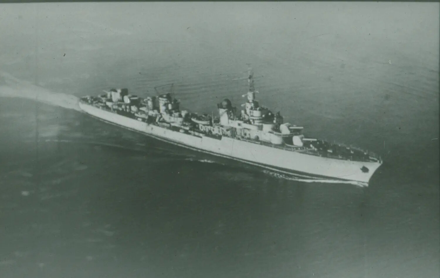Aerial View of a U.S. Navy Cruiser Underway at Sea, World War II Era