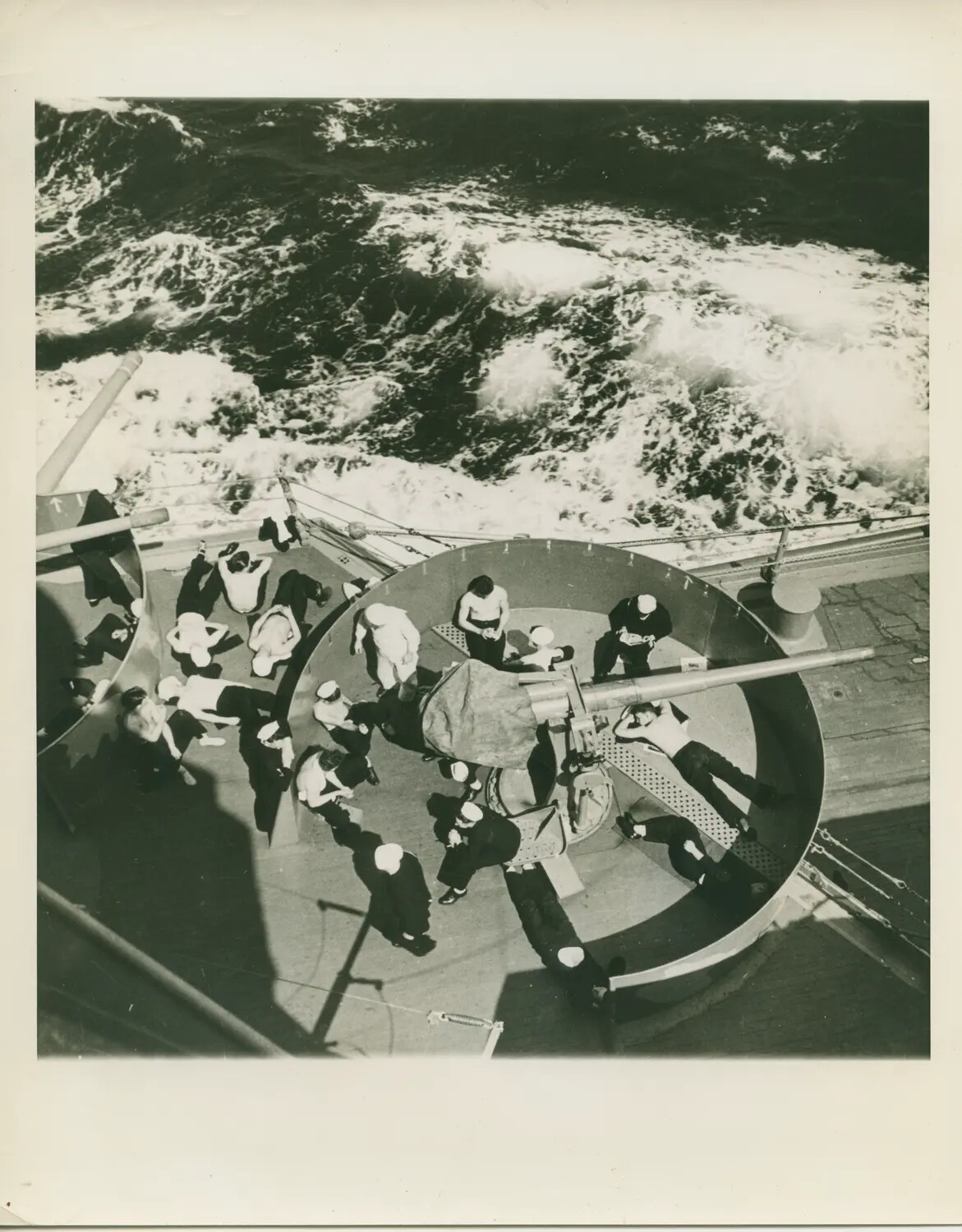 Sailors Relax at Anti-Aircraft Gun Mount Aboard Warship Underway, WWII