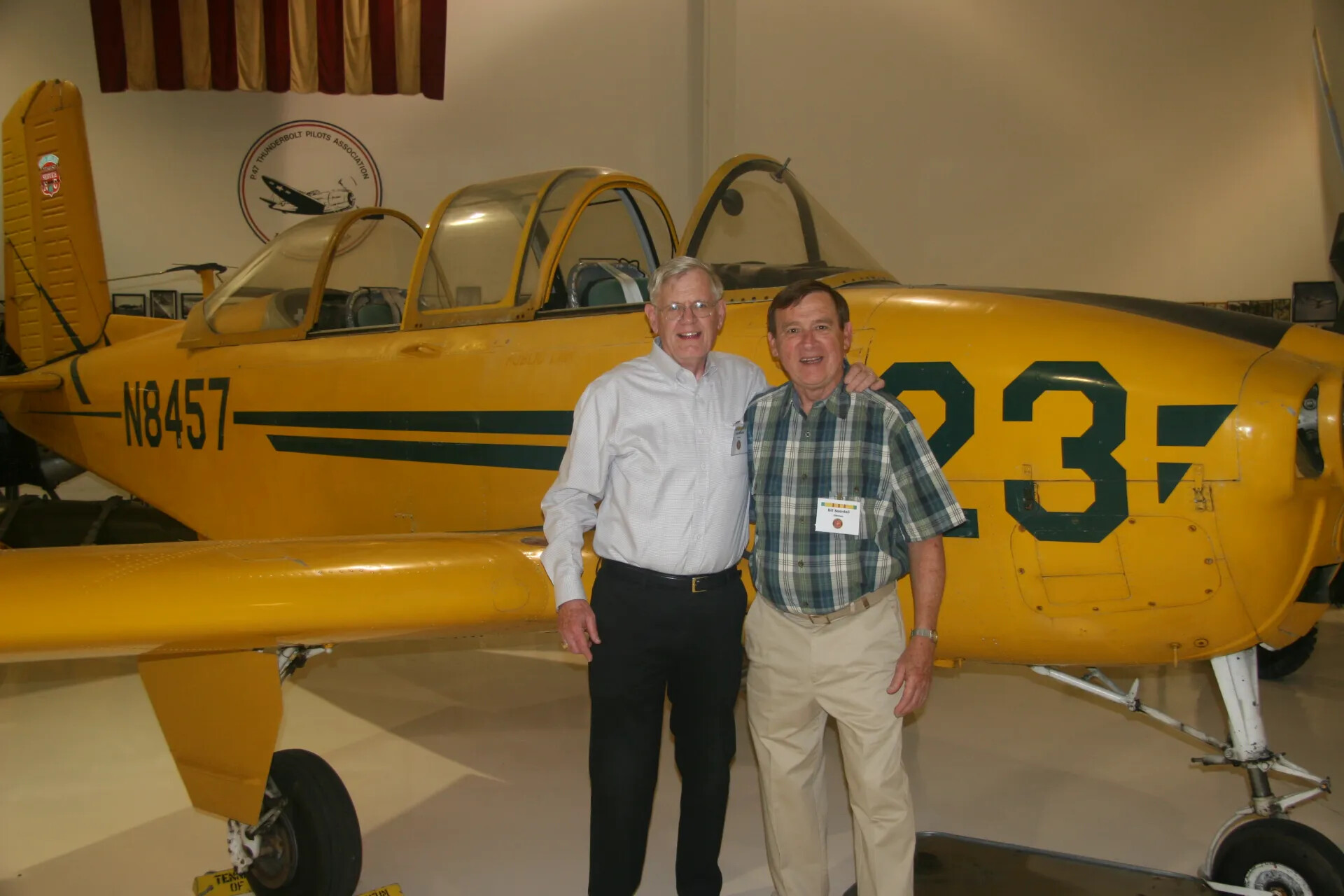 Two Veterans Posing Together with Vintage Training Aircraft at Aviation Museum, 2016