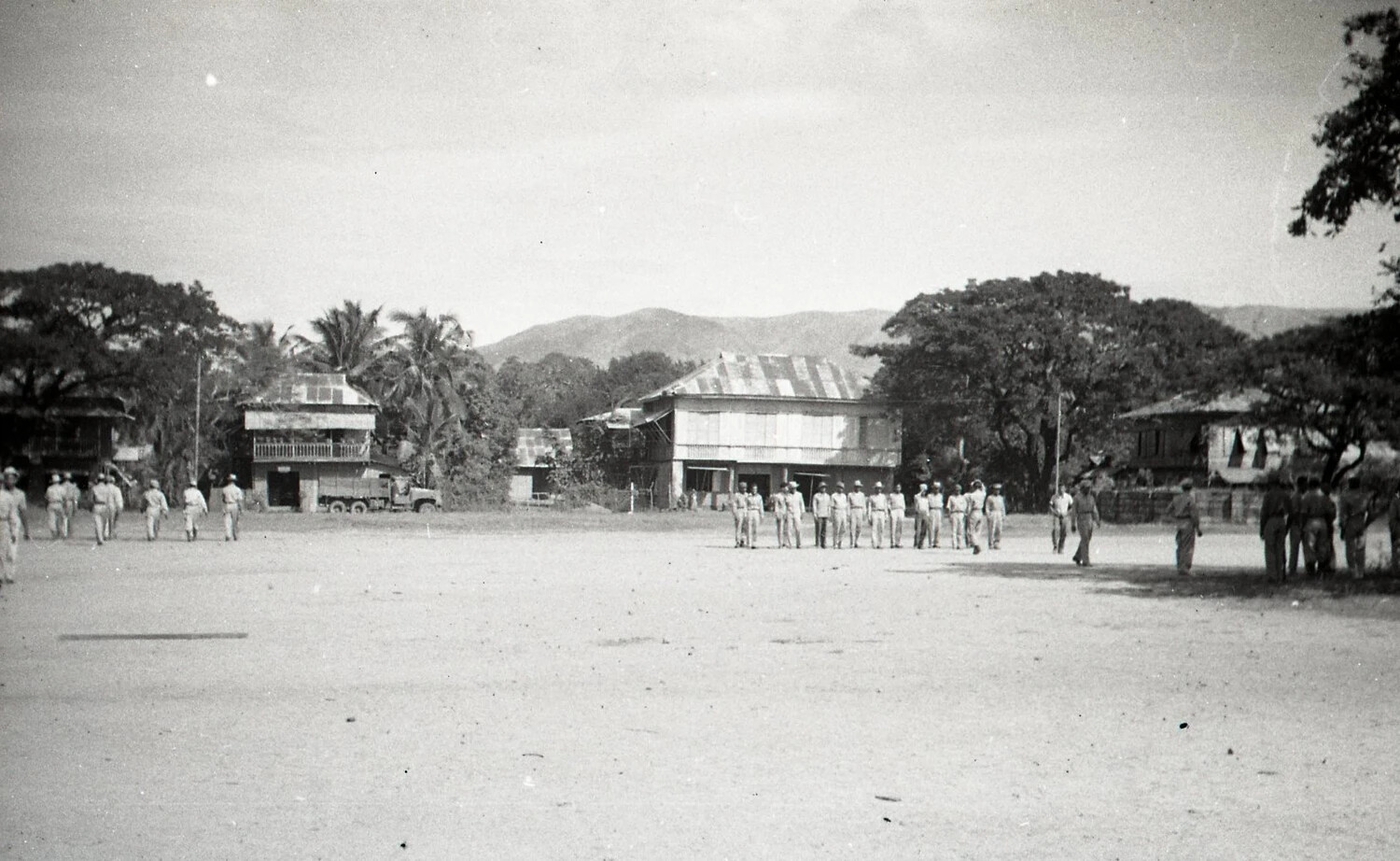 U.S. or Filipino Troops Dispersing Across a Town Plaza, Luzon, Philippines, WWII Era