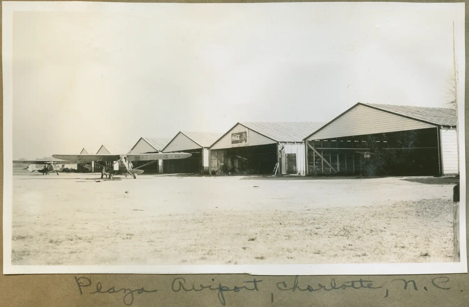 High-Wing Monoplane and Hangar Row, Plaza Airport, Charlotte, North Carolina, c. early-to-mid 1930s