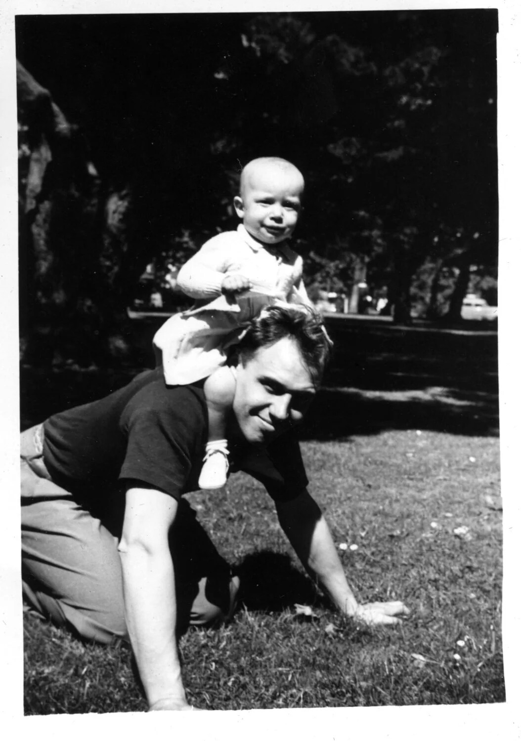 Informal Snapshot of a Man Giving an Infant a Piggyback Ride in a Park